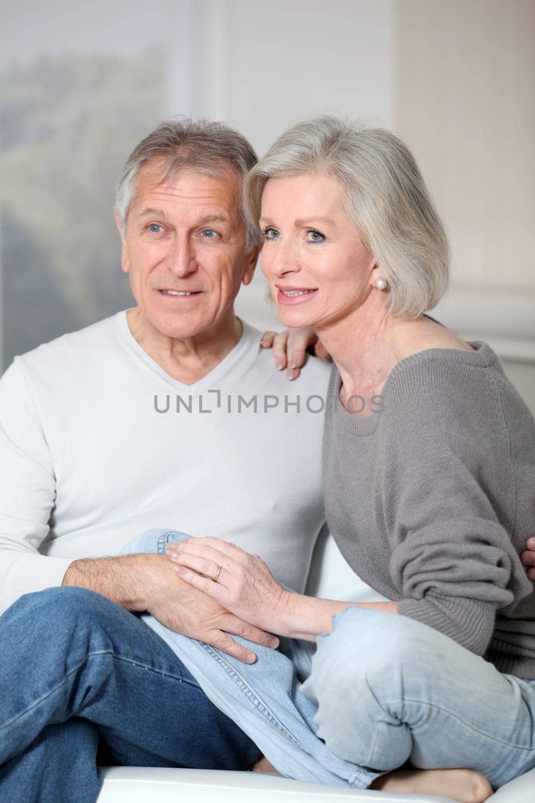 Portrait of happy senior couple sitting in sofa