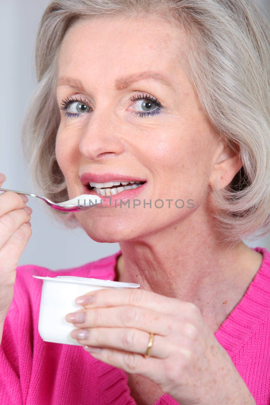 Portrait of senior woman eating yoghurt