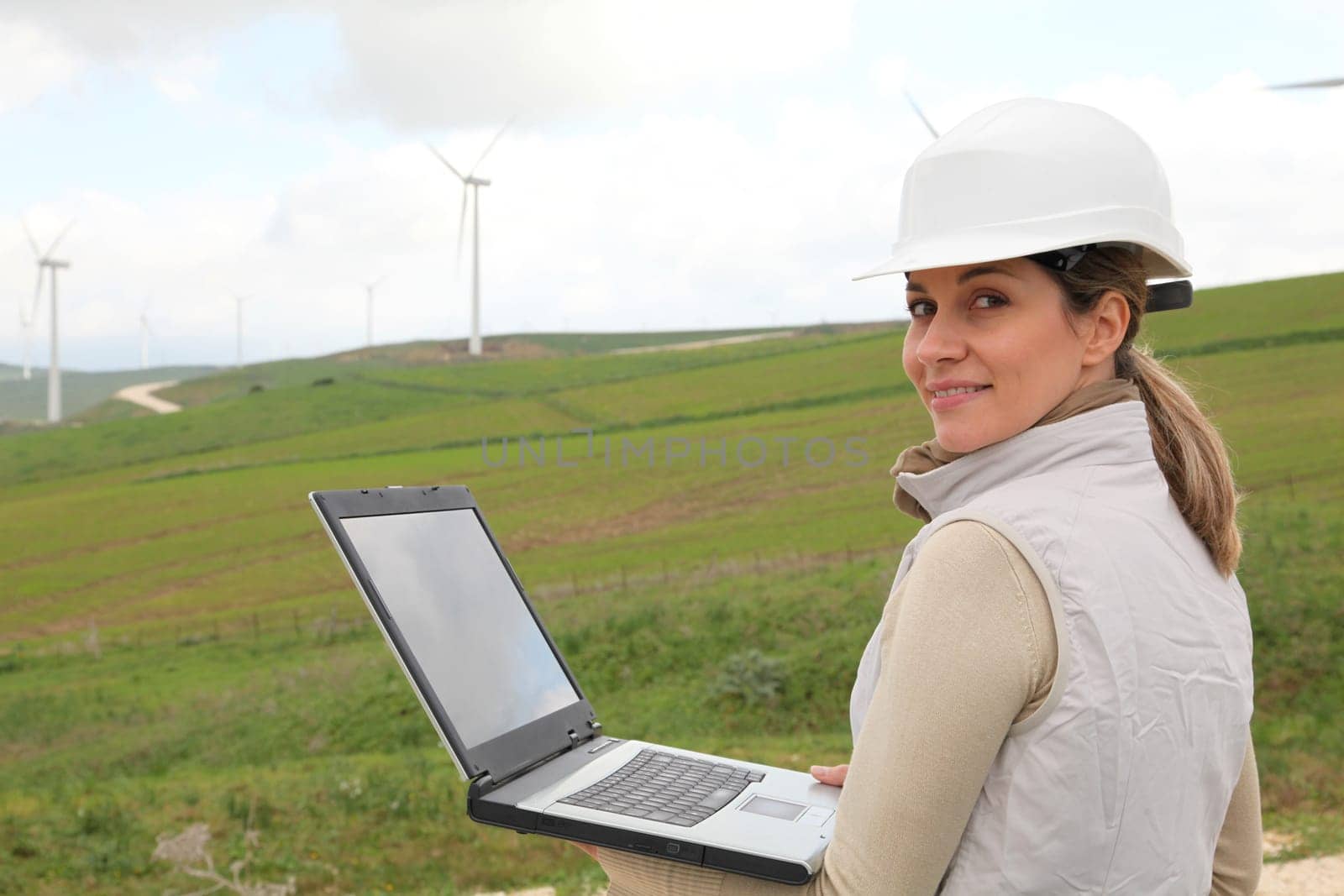 Engineer working on laptop computer in wind turbines field