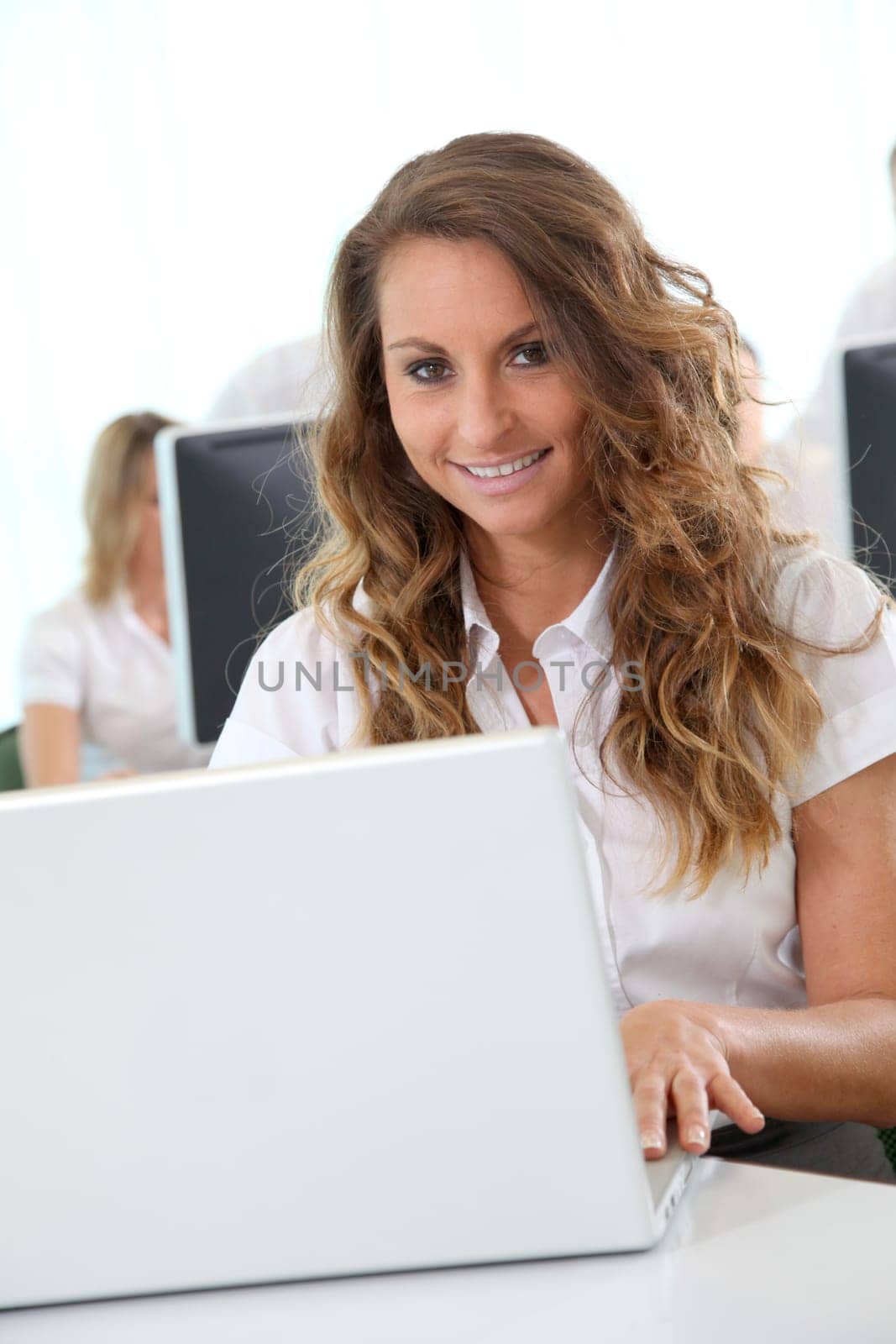 Smiling office worker in front of laptop computer