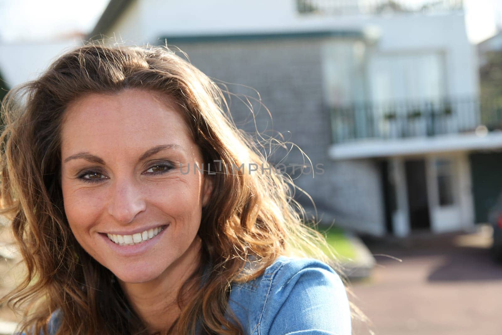 Beautiful woman standing against home fence
