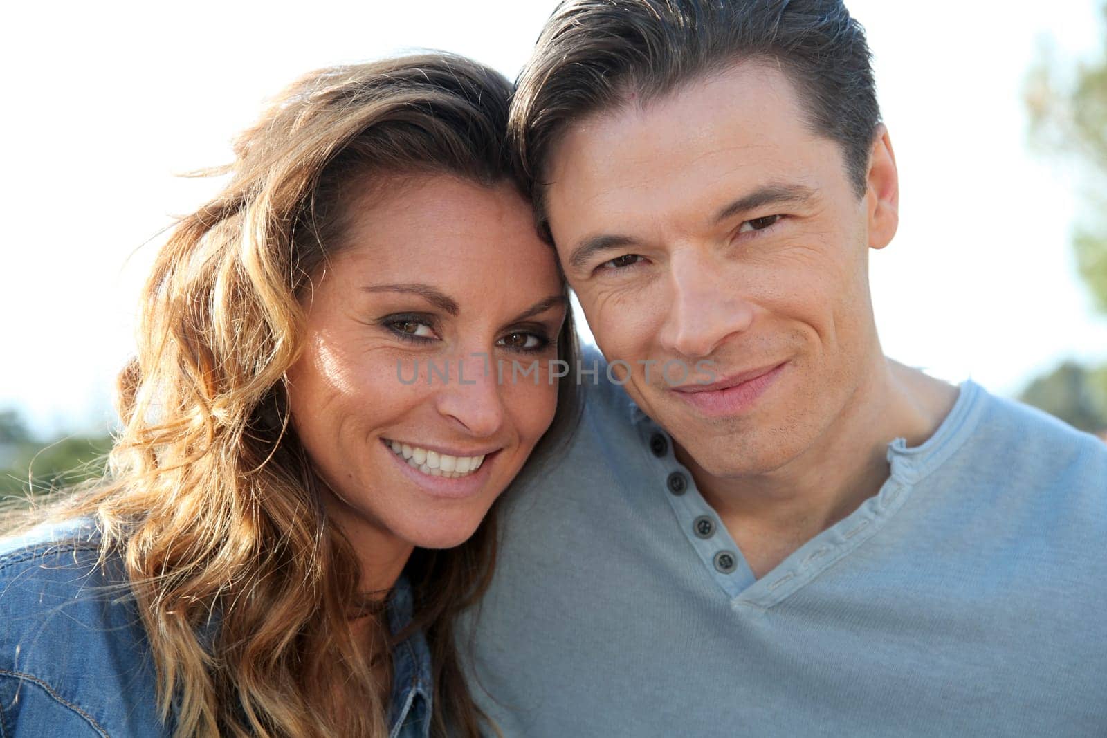 happy couple standing outside on a sunny day
