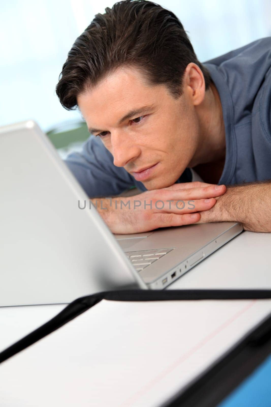 Office worker with exhausted look in front of computer