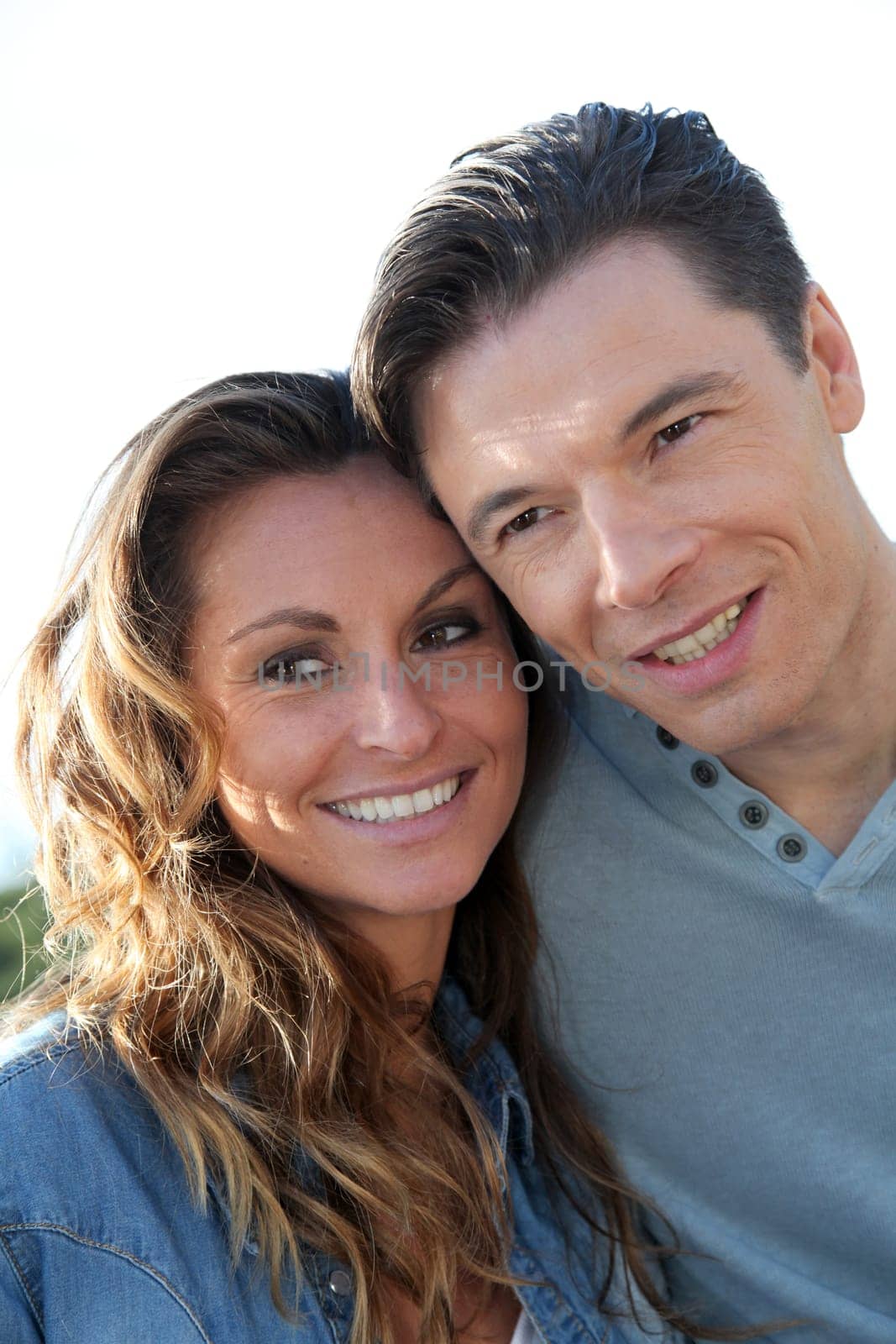 happy couple standing outside on a sunny day