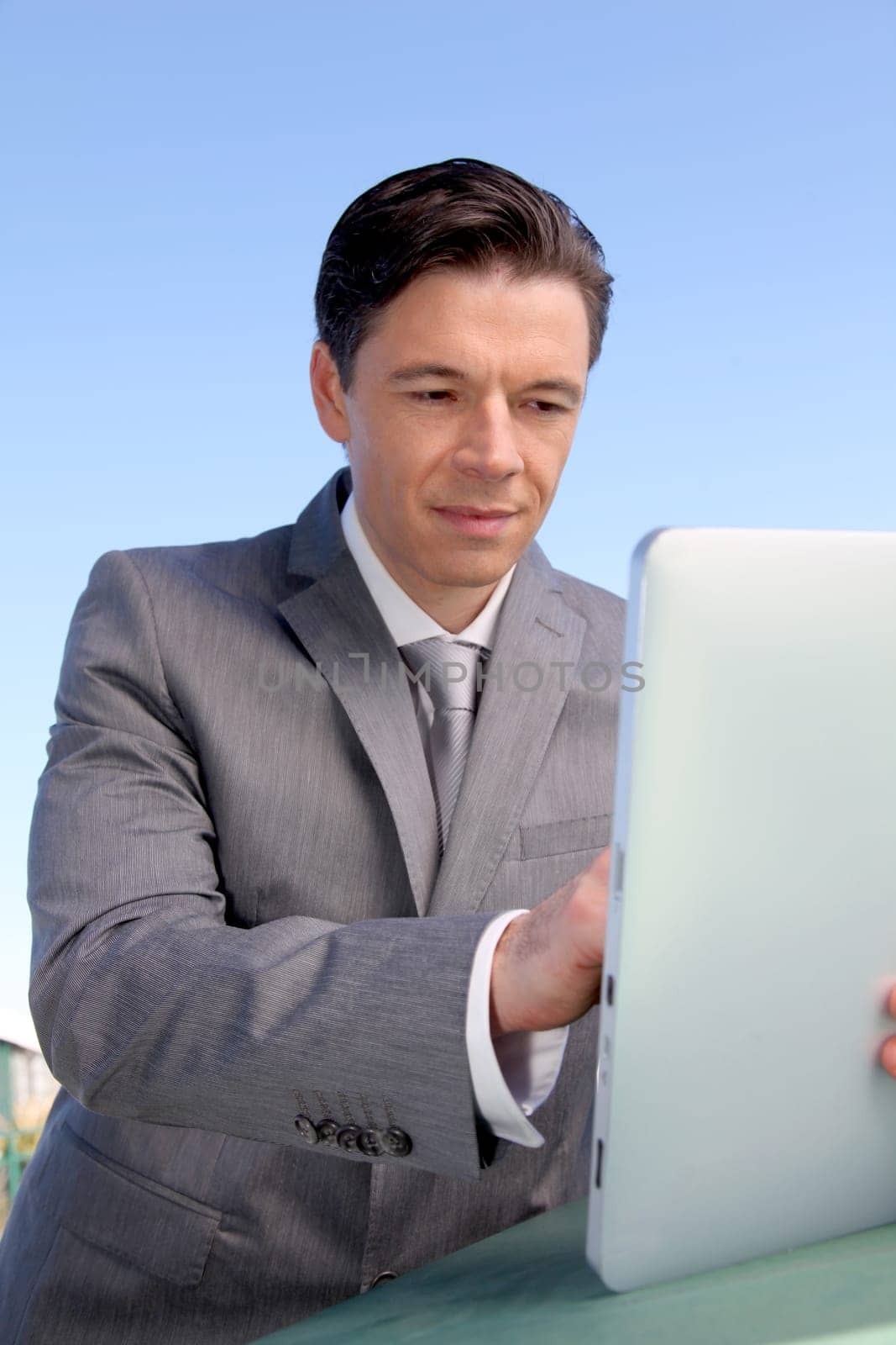 Portrait of businessman working on electronic tablet