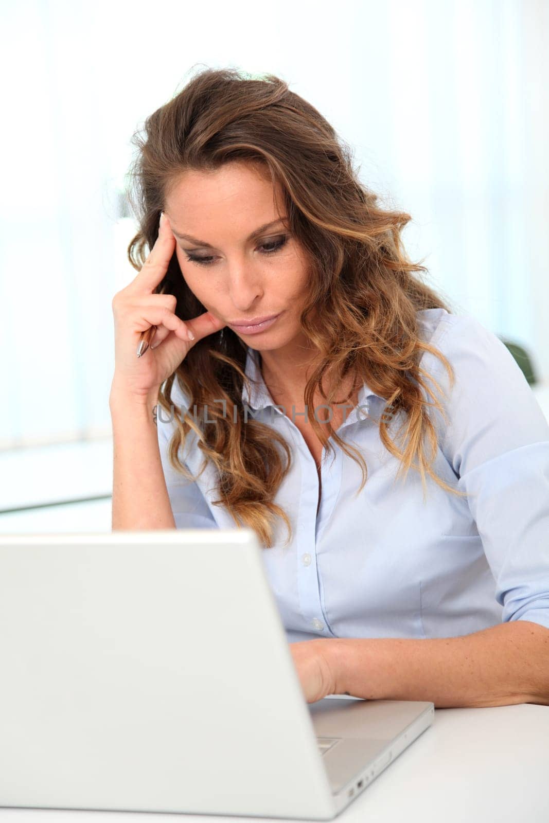 Office worker with desperate look in front of laptop