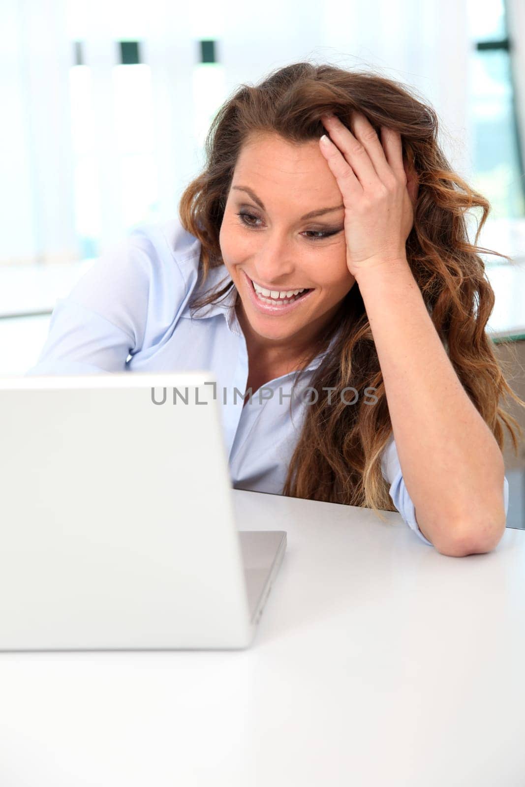 Office worker having fun in front of laptop computer