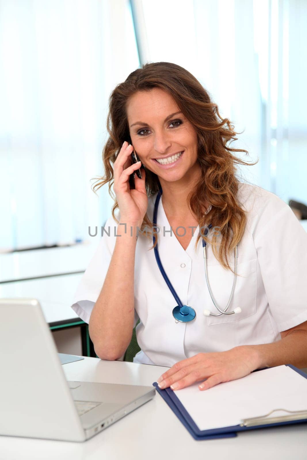 Beautiful nurse talking on mobile phone