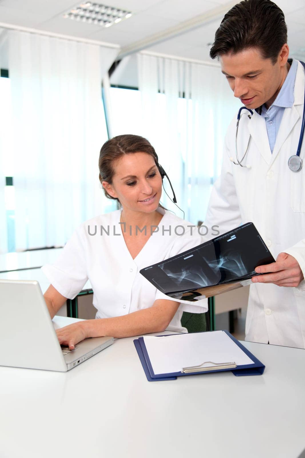 Doctor showing xray results to medical secretary