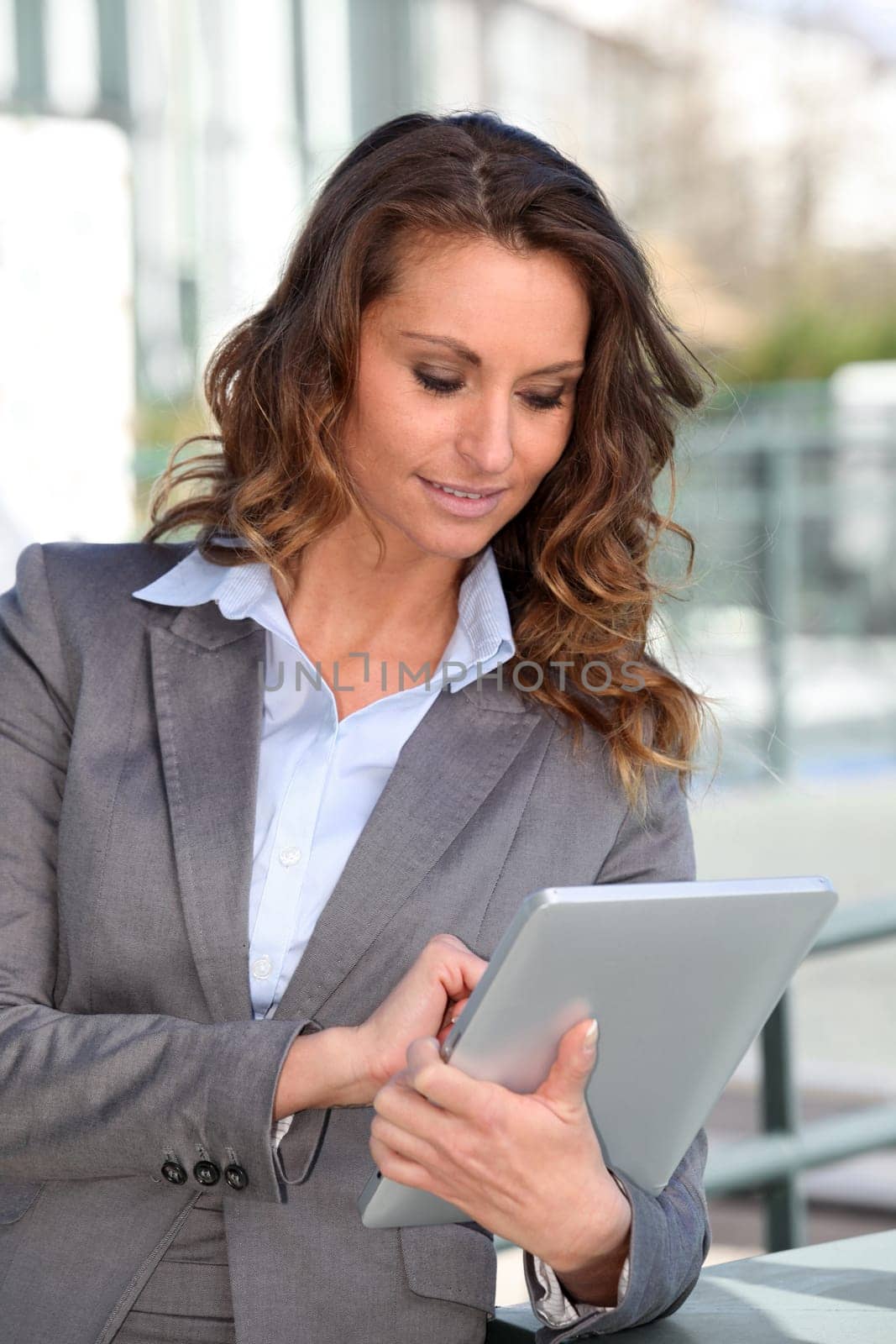 Smiling businesswoman using electronic tablet outside