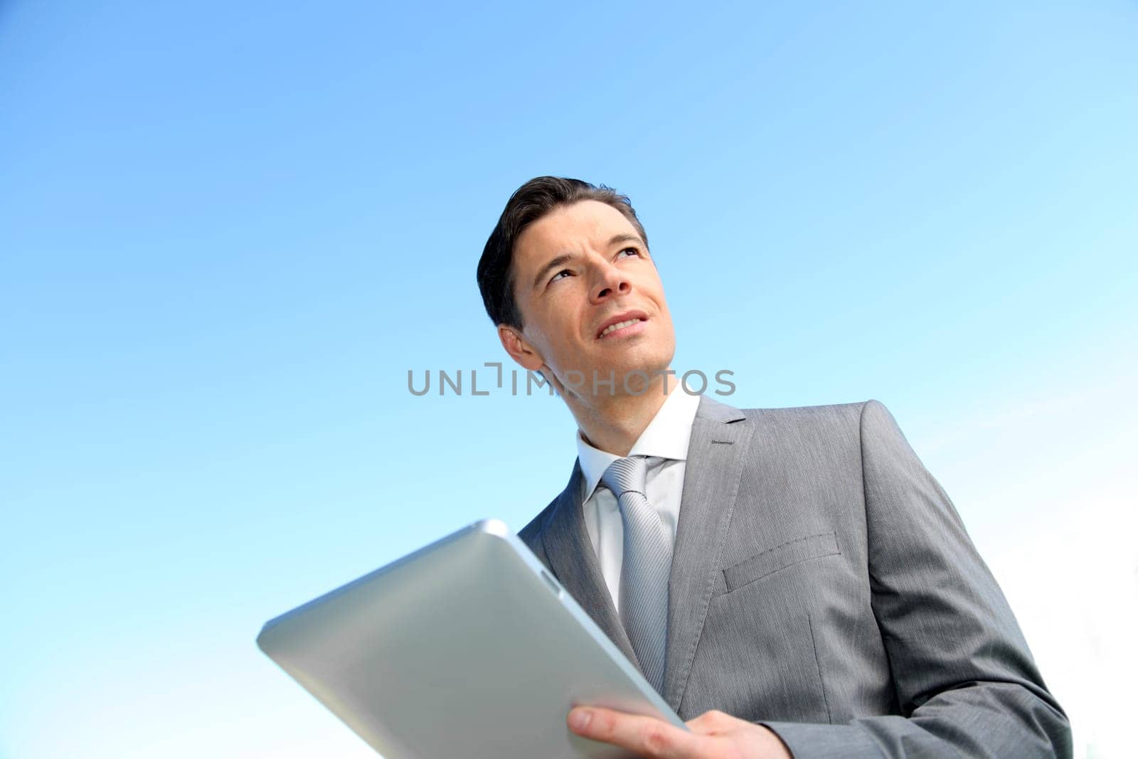 Portrait of businessman working on electronic tablet