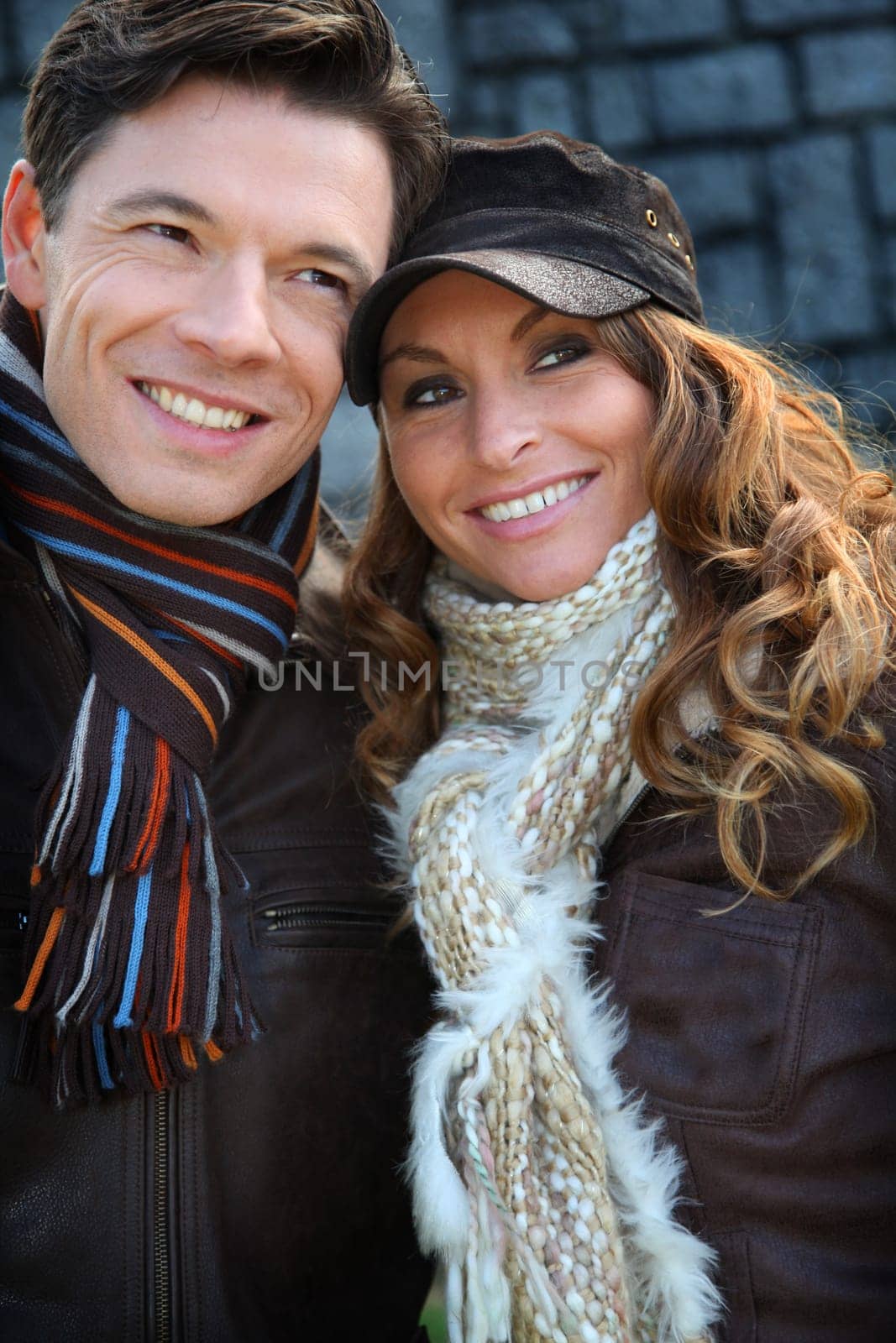 Portrait of happy couple wearing scarves in winter time