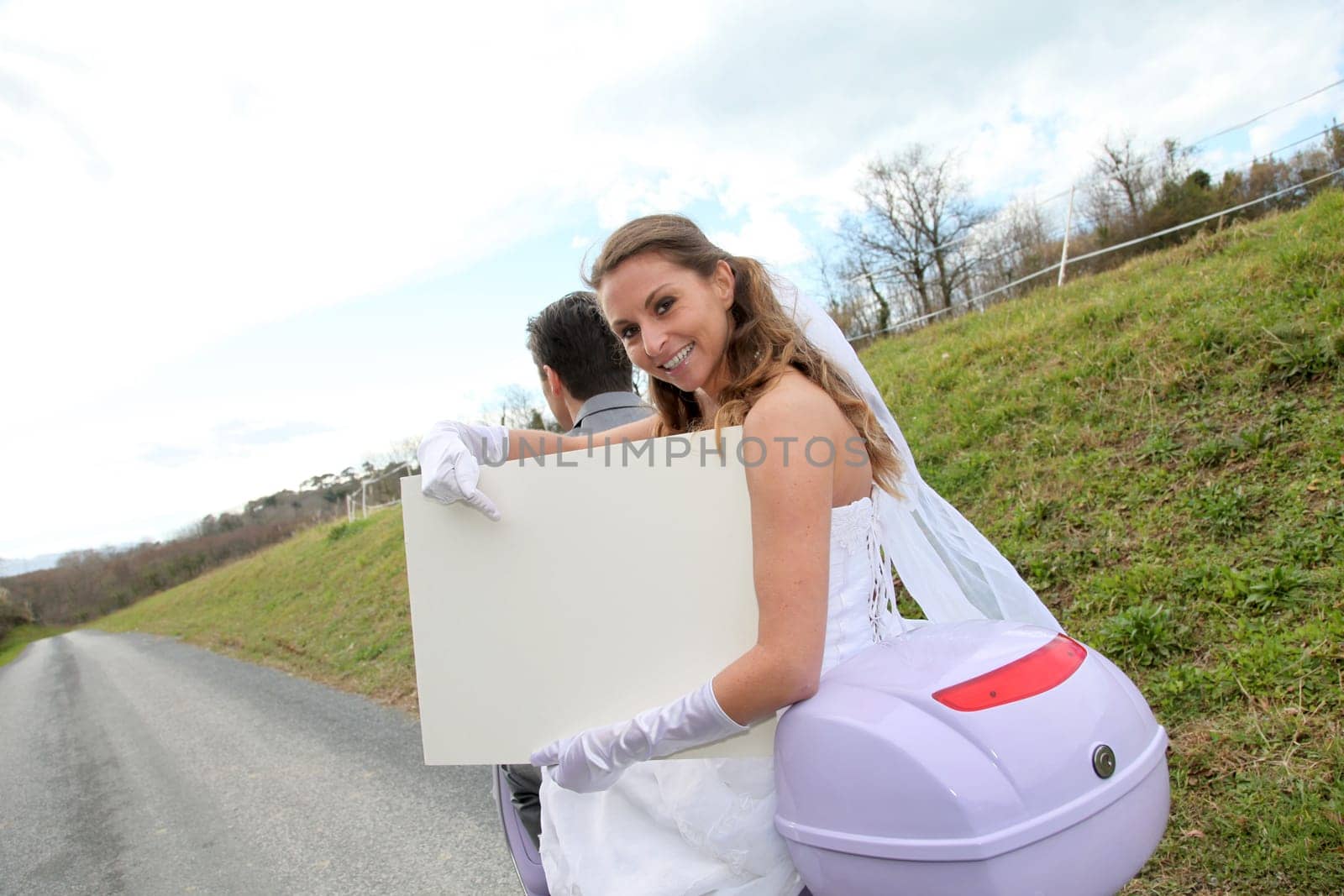 Bride on a motorcycle ride holding whiteboard