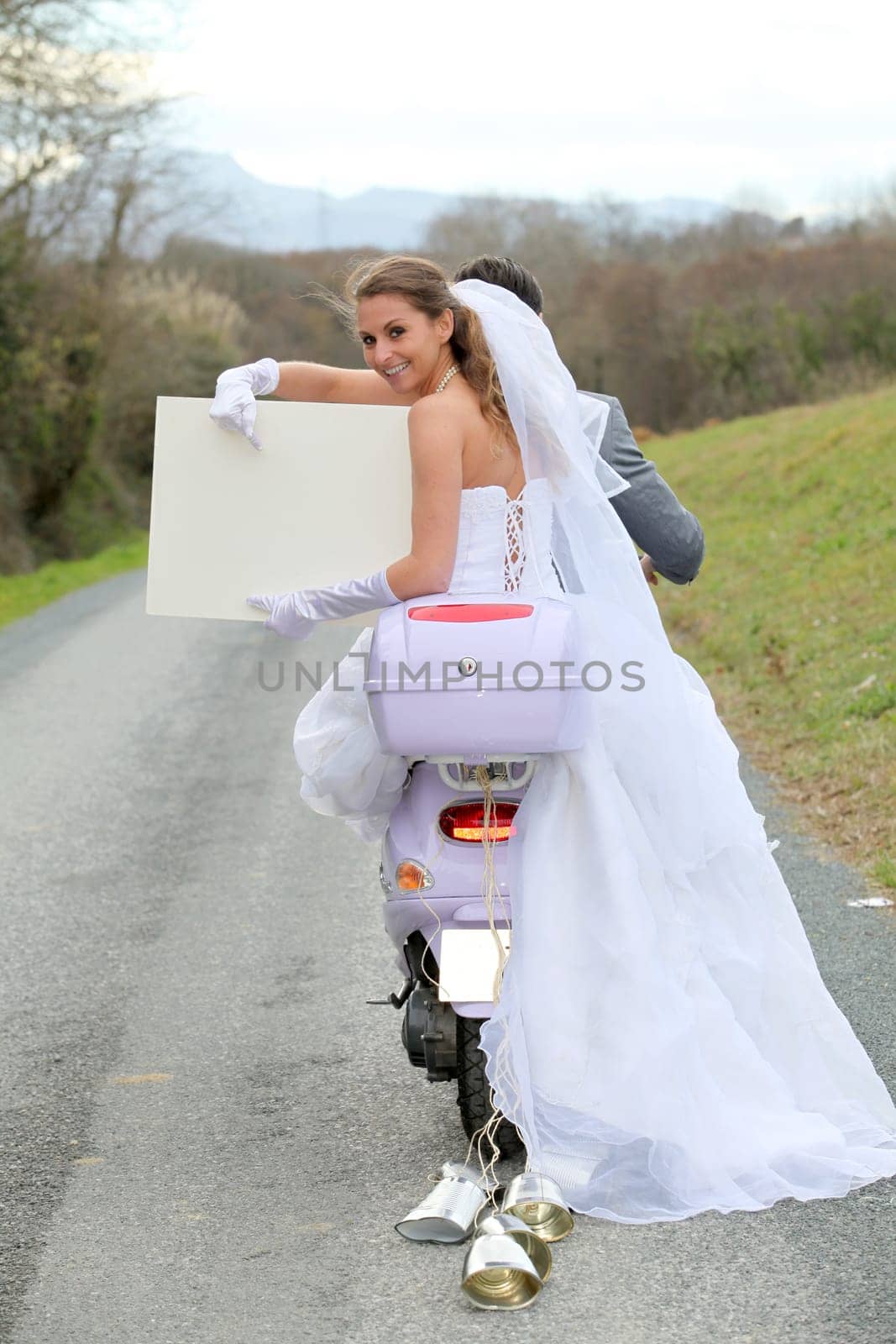 Bride on a motorcycle ride holding whiteboard