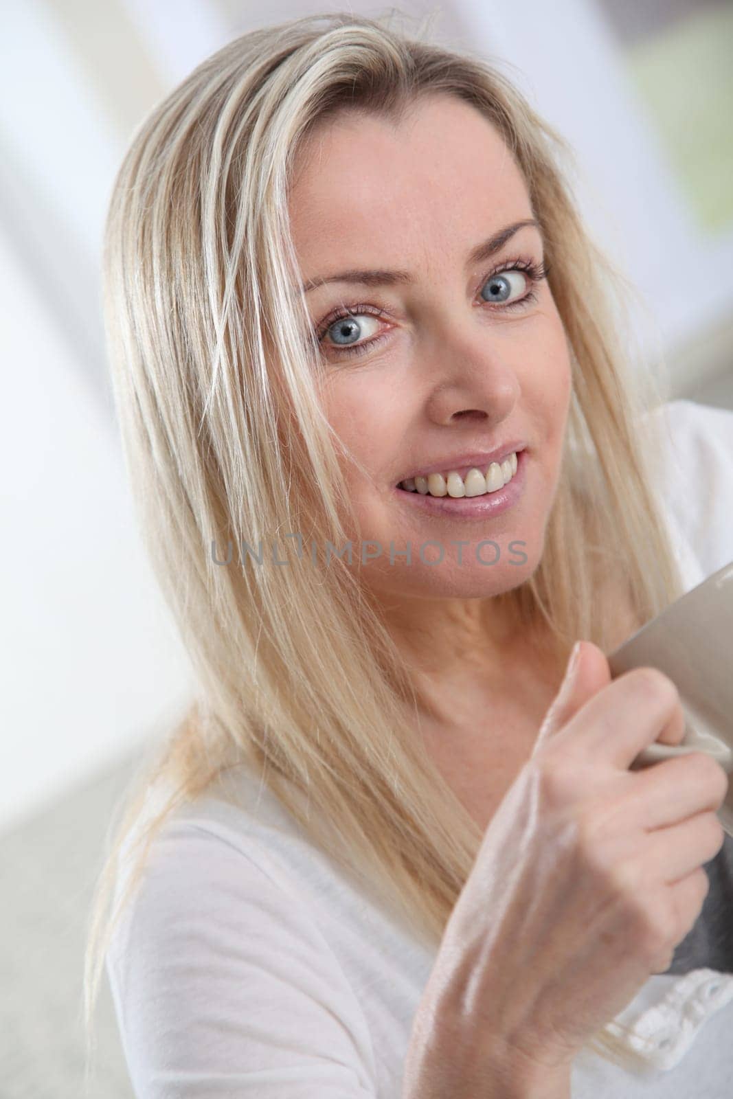 Portrait of beautiful blond woman drinking tea