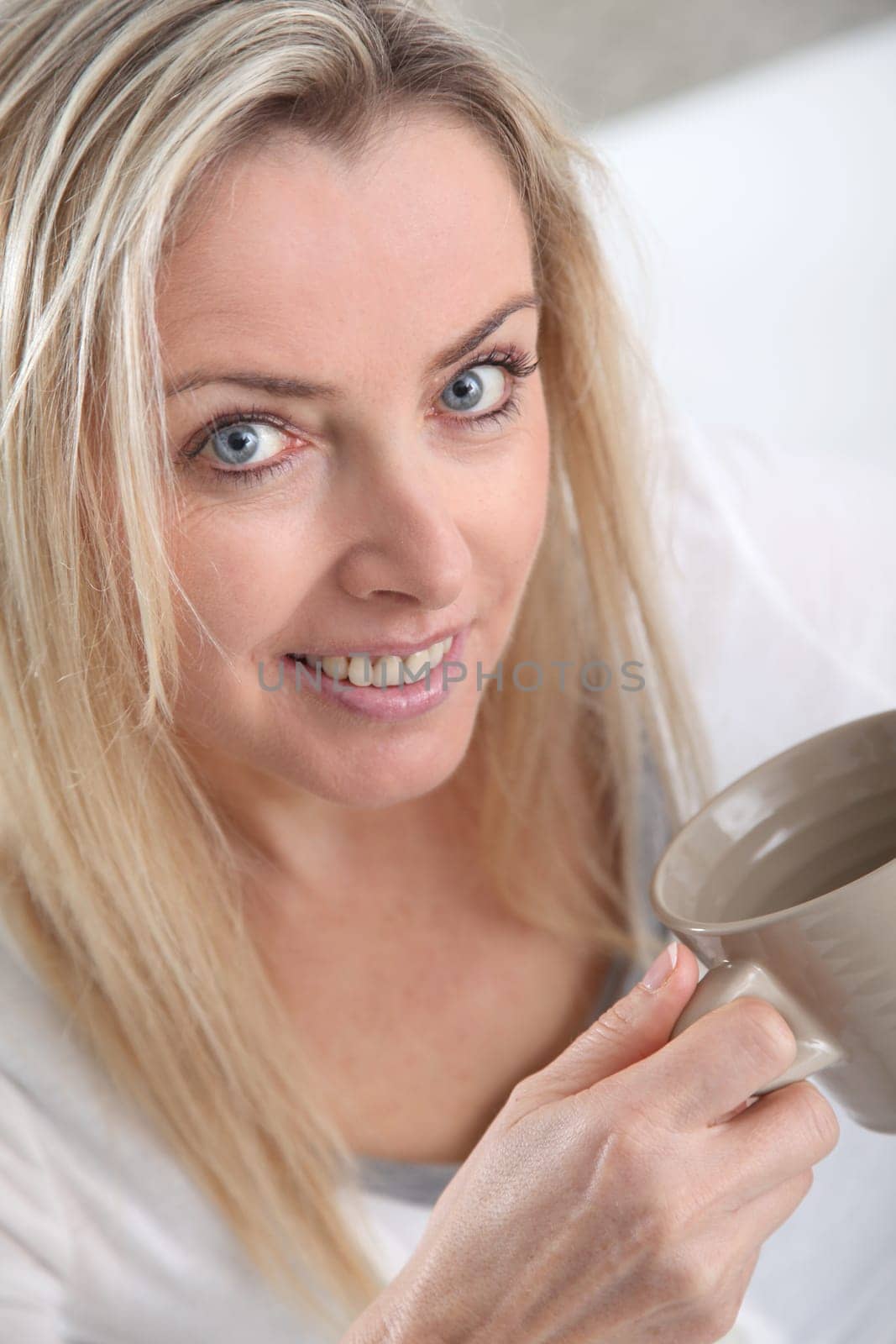 Portrait of beautiful blond woman drinking tea