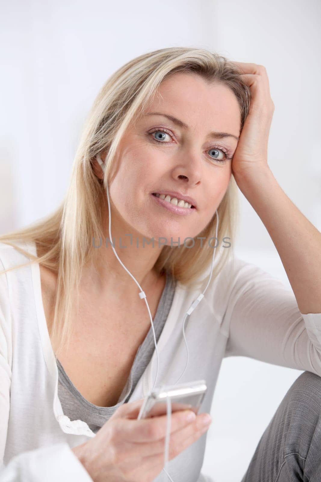 Beautiful blond woman listening to music