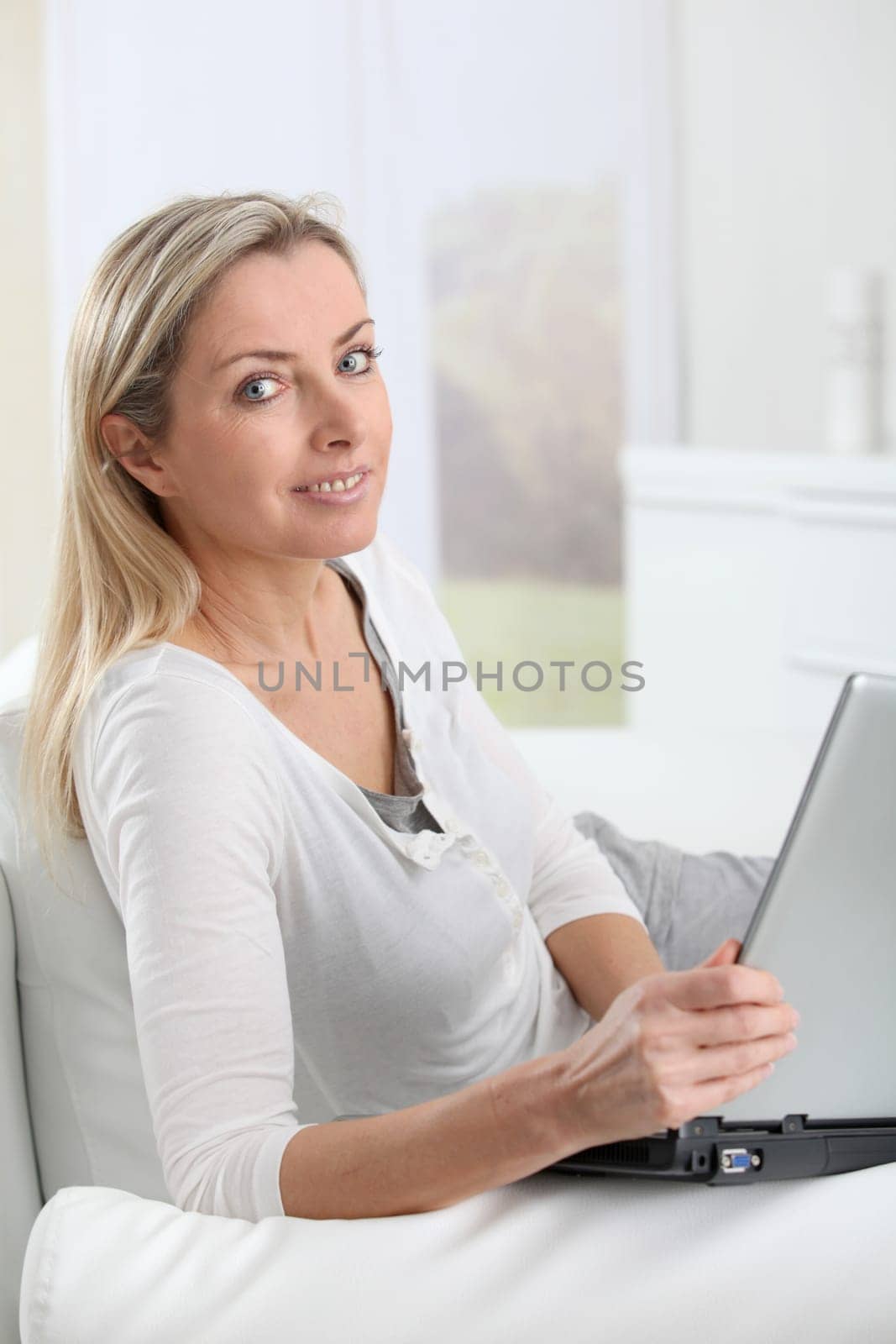 Adult blond woman connected on internet at home