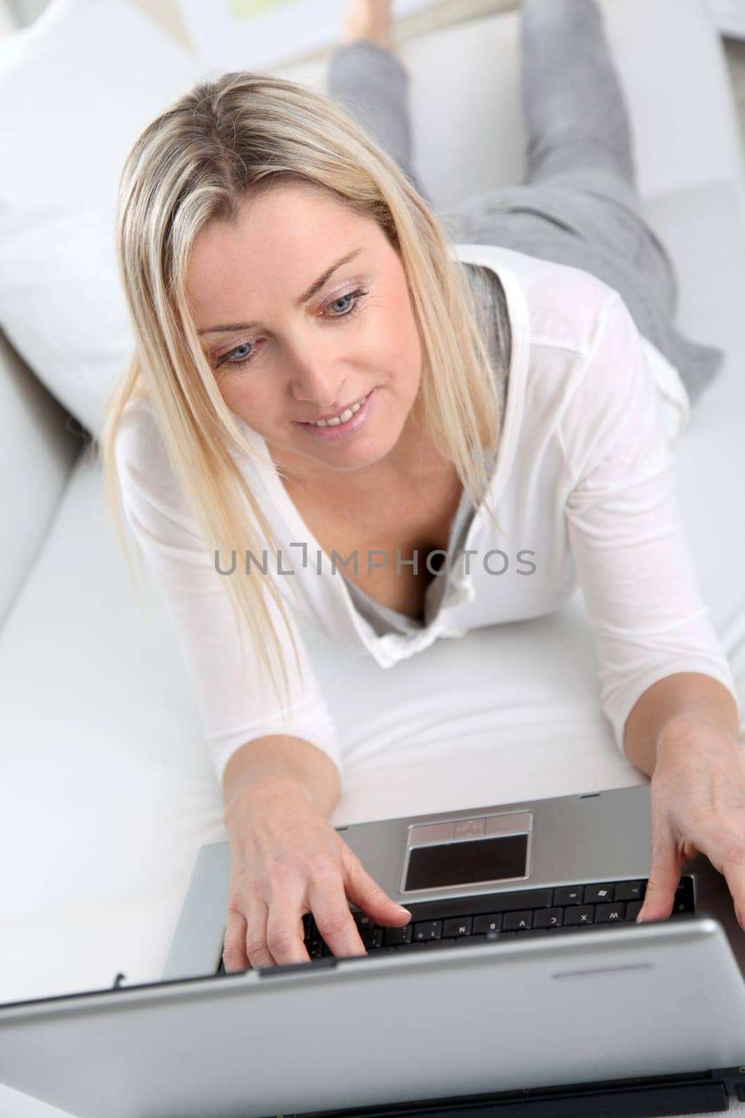 Adult blond woman connected on internet at home