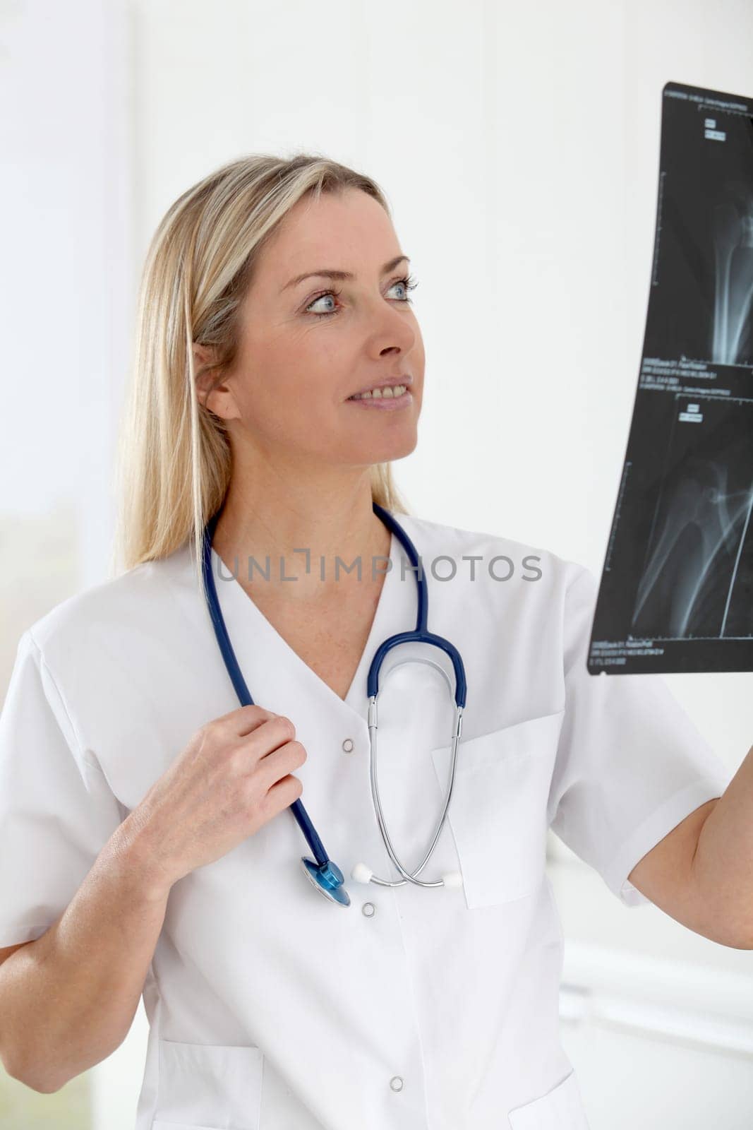 Beautiful blond nurse looking at X-ray