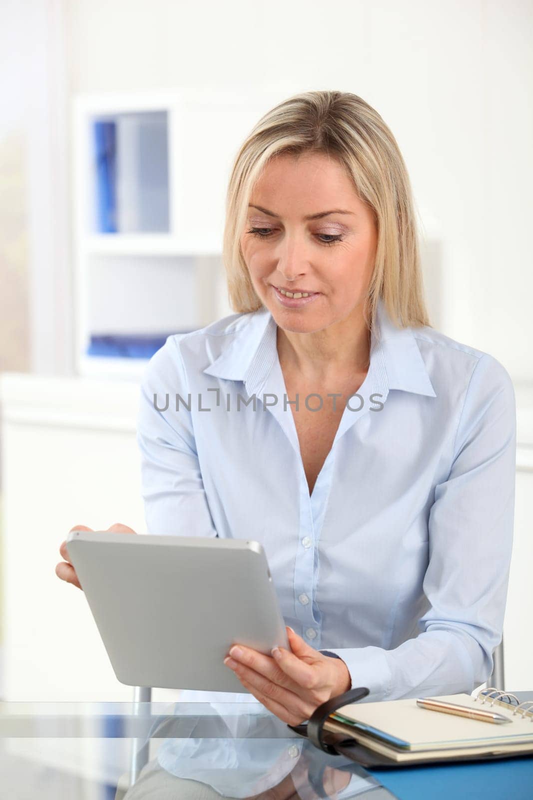 Portrait of office worker using electronic tablet in office