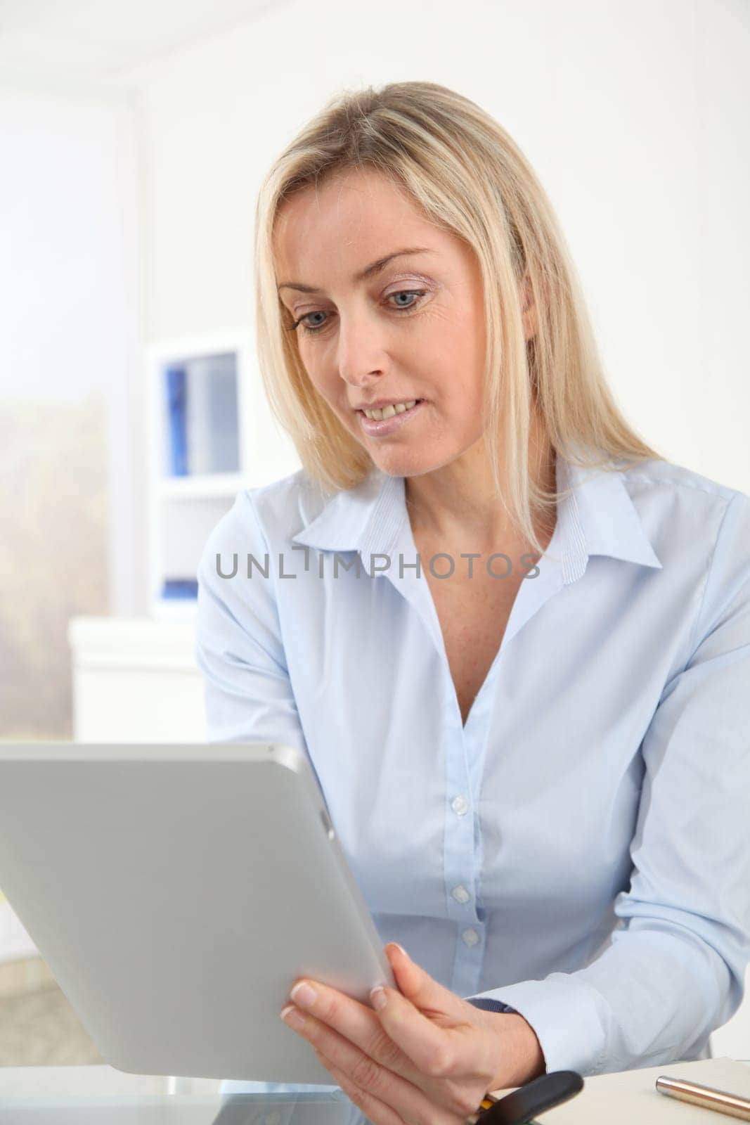 Portrait of office worker using electronic tablet in office