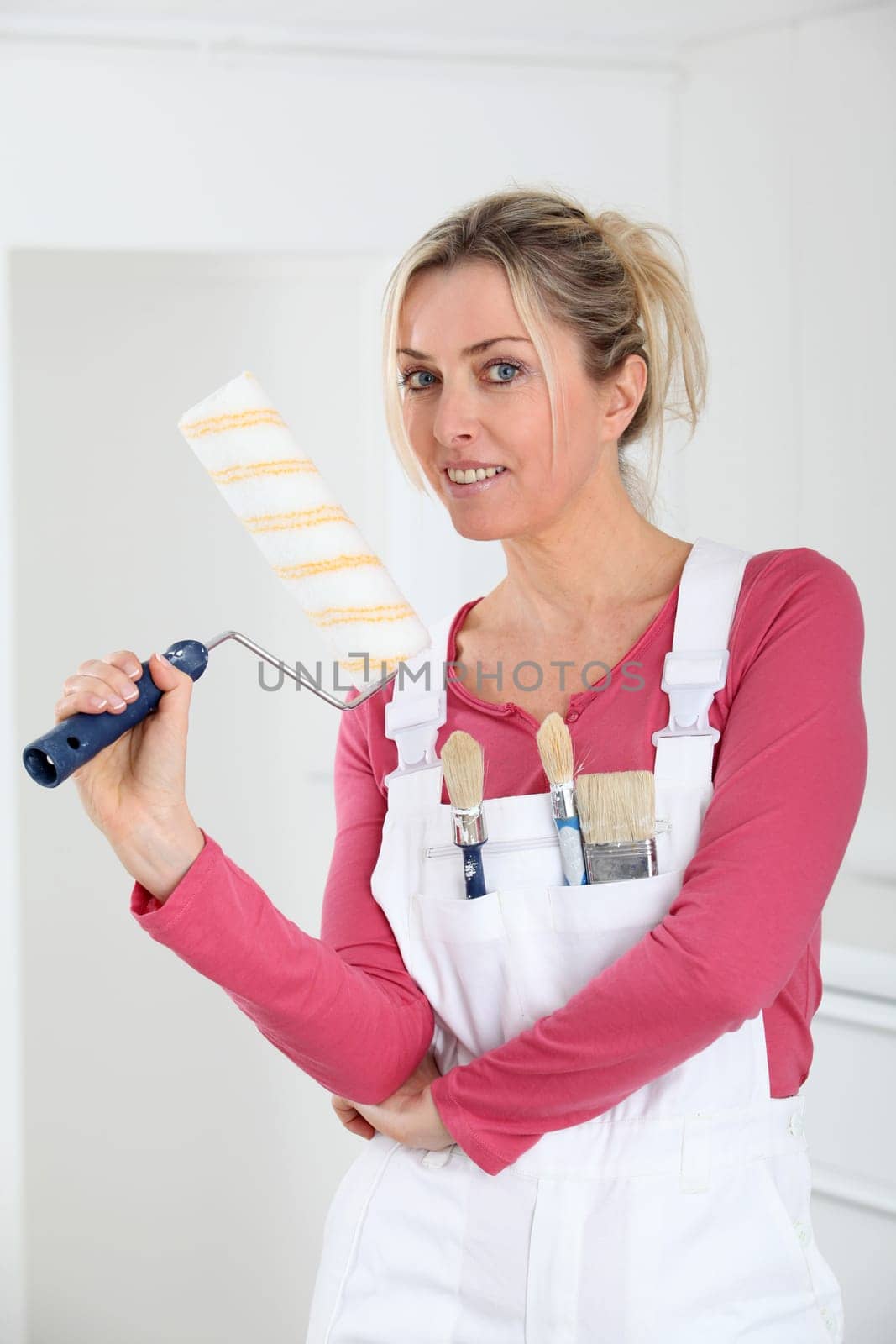 Beautiful blond woman with paint roller