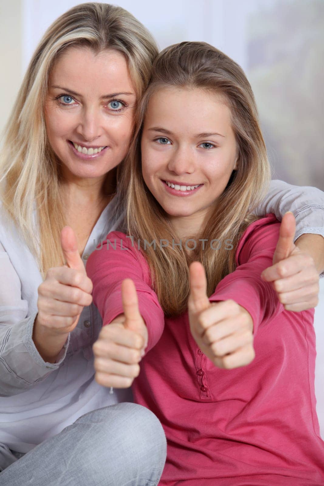 Portrait of mother and daughter with thumbs up