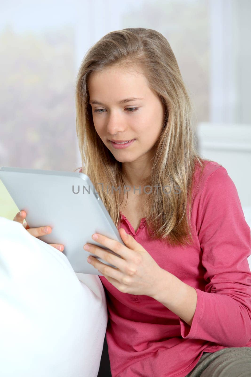 Teenager websurfing on electronic touchpad at home