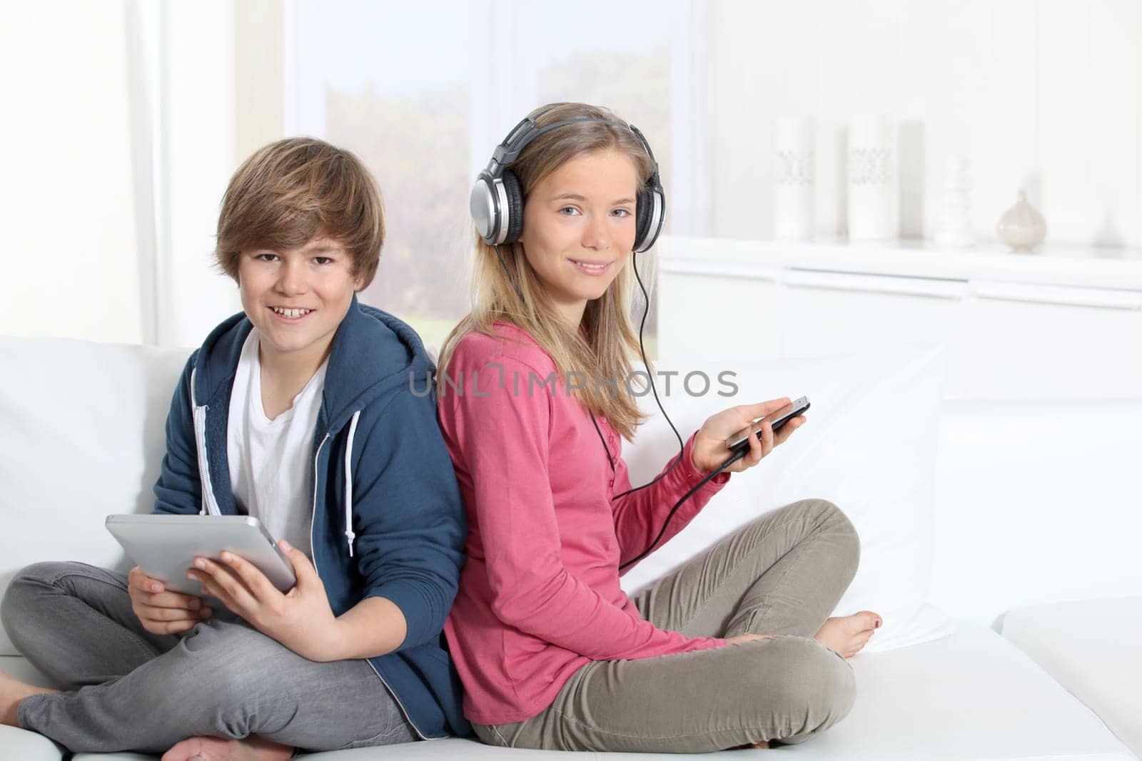Teenagers sitting in sofa with electronic devices