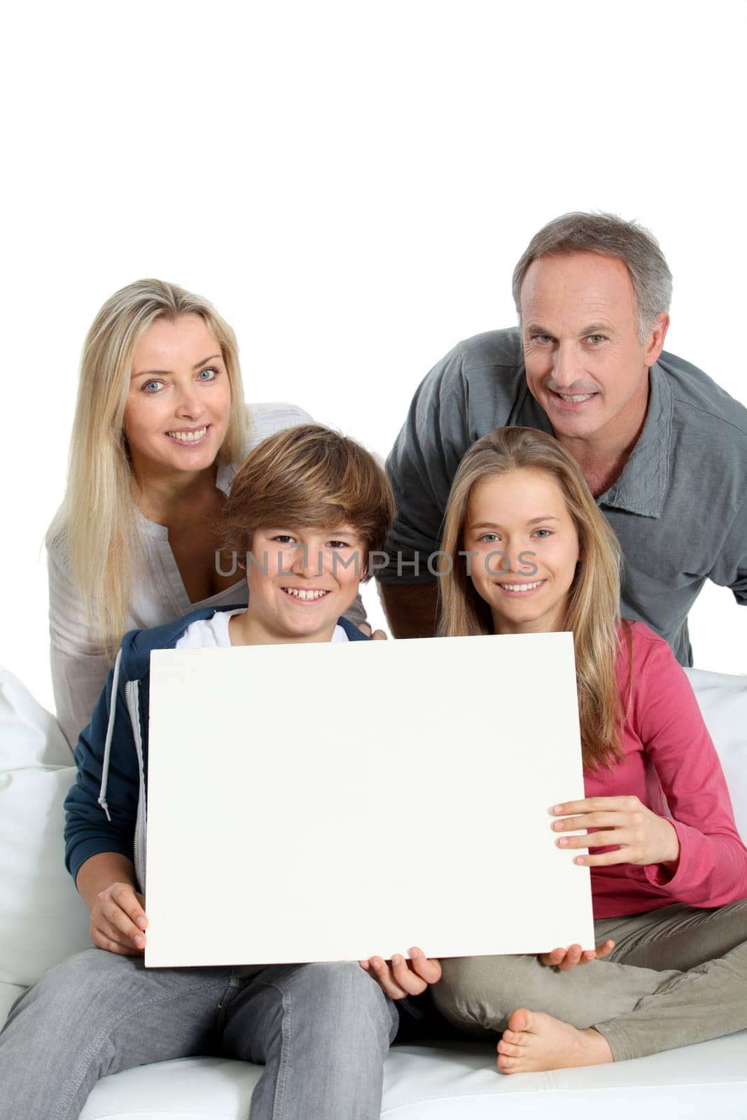 Portrait of happy family holding white message board