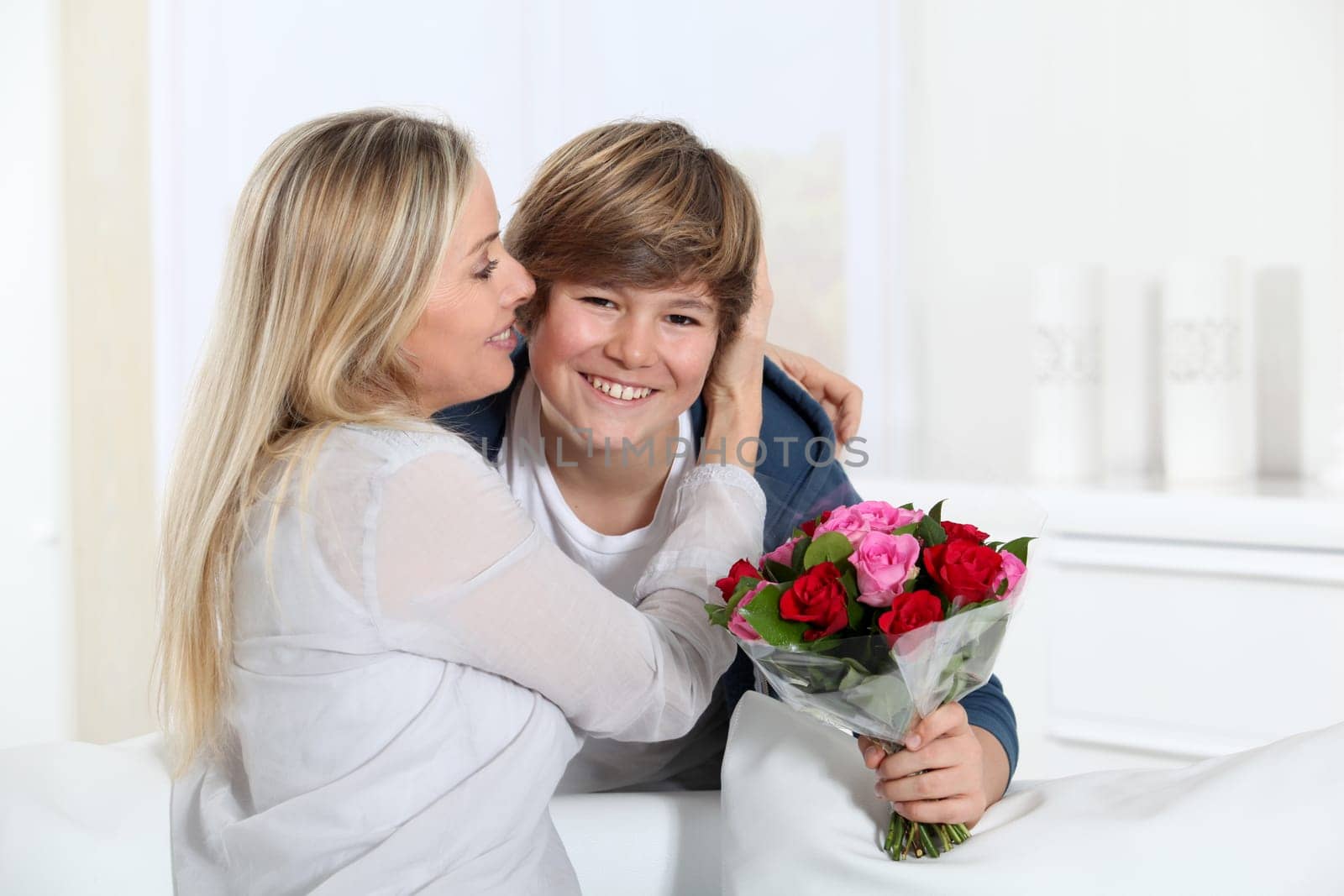 Son offering bunch flowers on mother's birthday