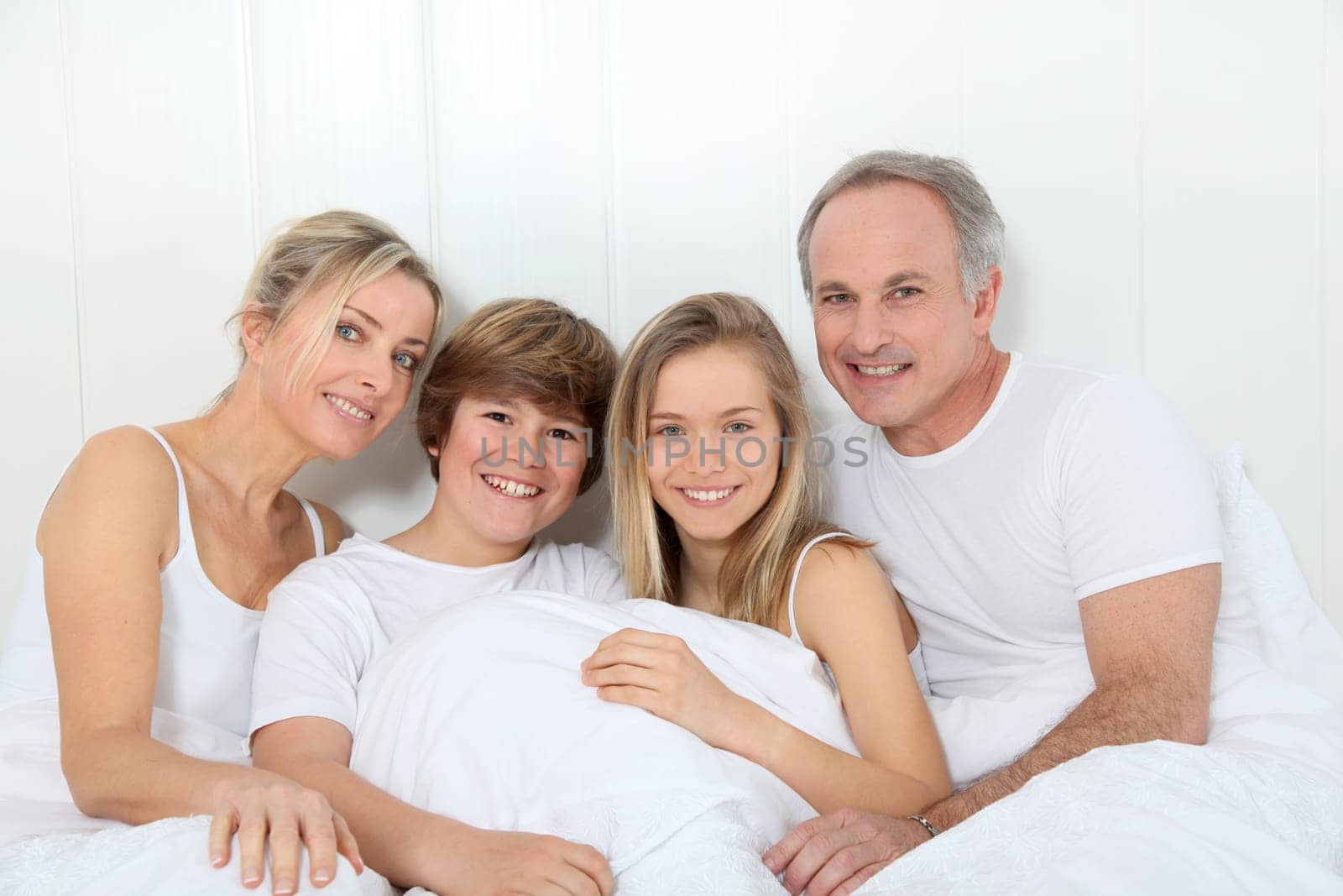 Portrait of happy family in bed in the morning
