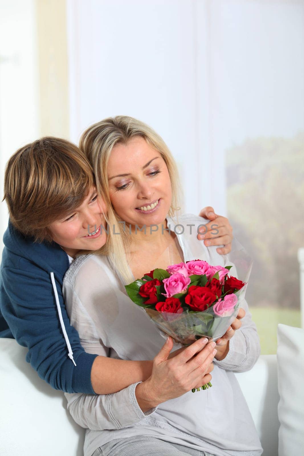 Son offering bunch flowers on mother's birthday