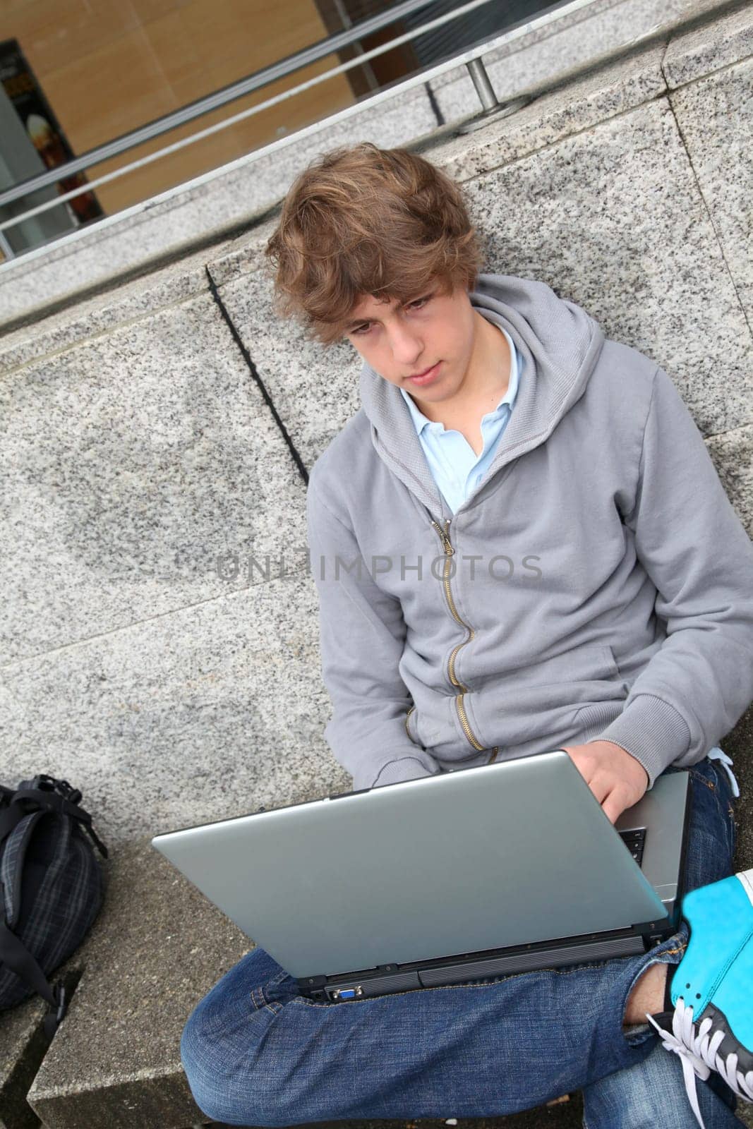 Student with laptop computer outside school building