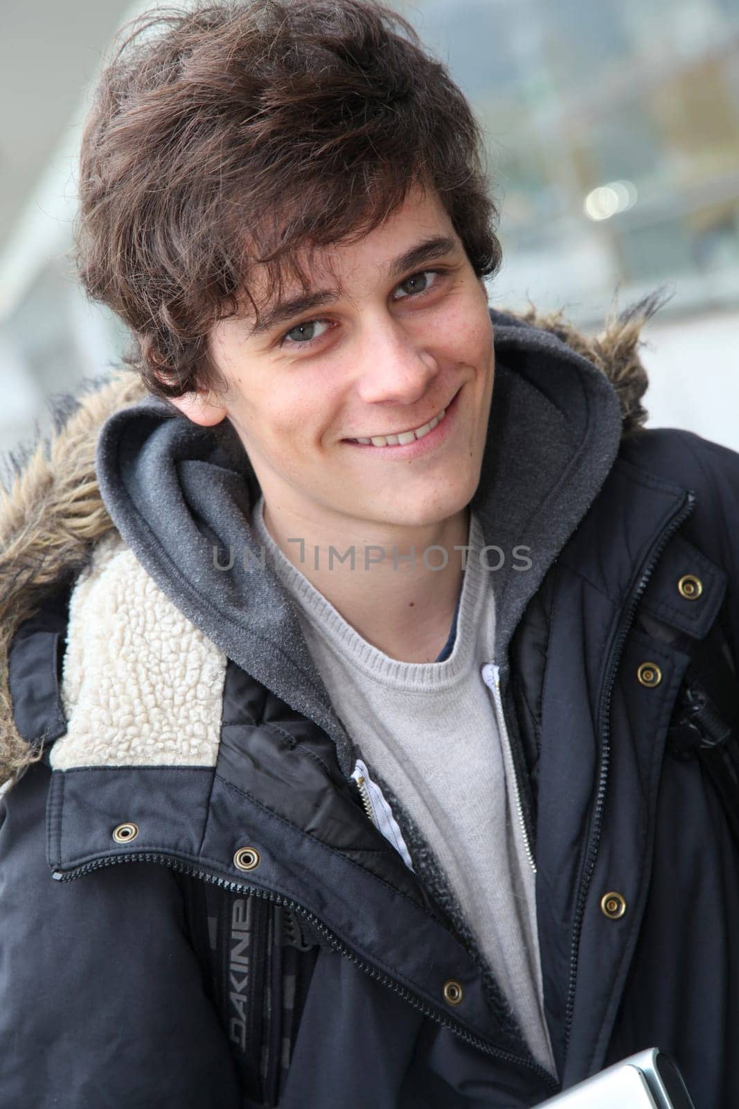 Portrait of teenage boy in front of school building