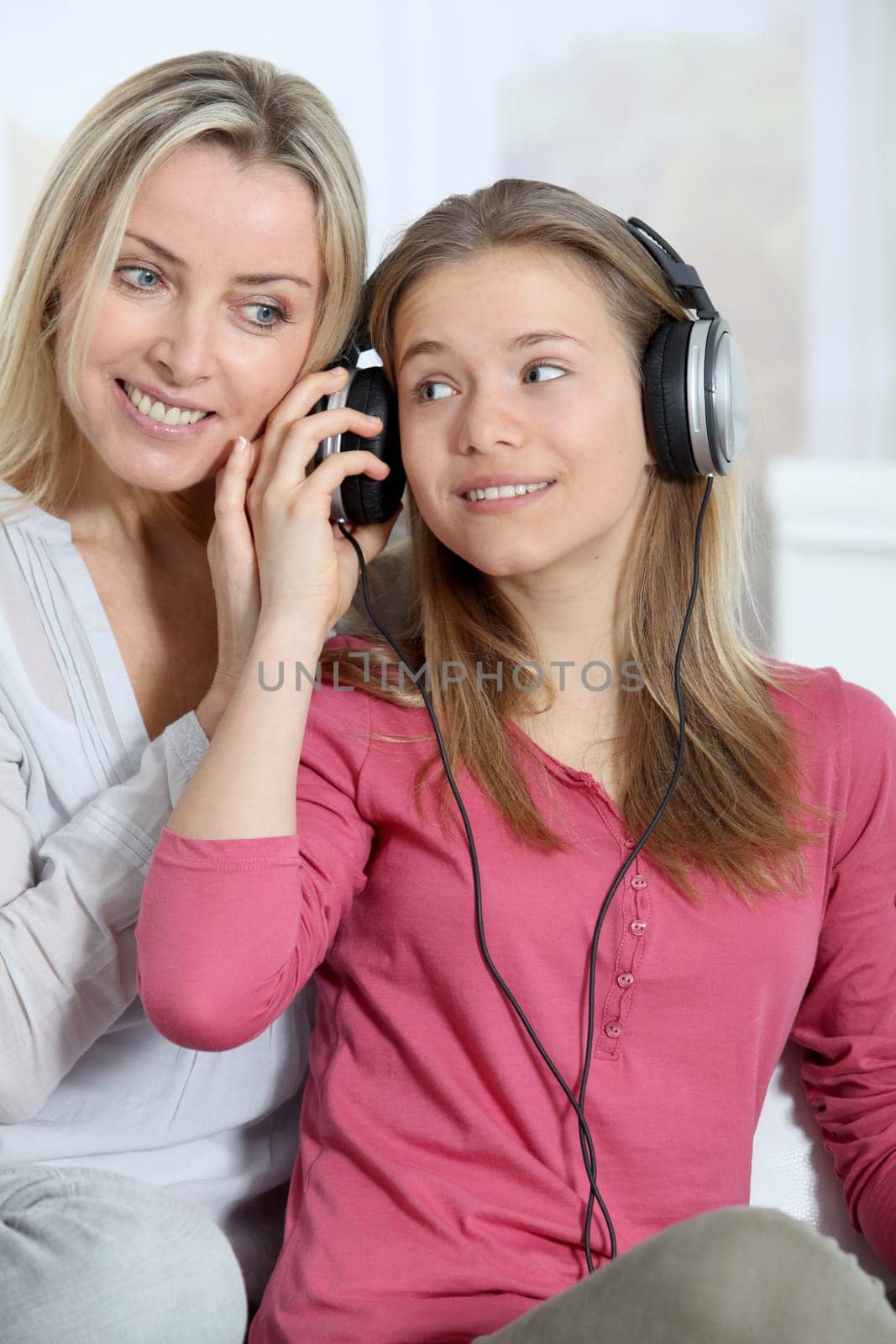 Mother and daughter listening to music whit headphones