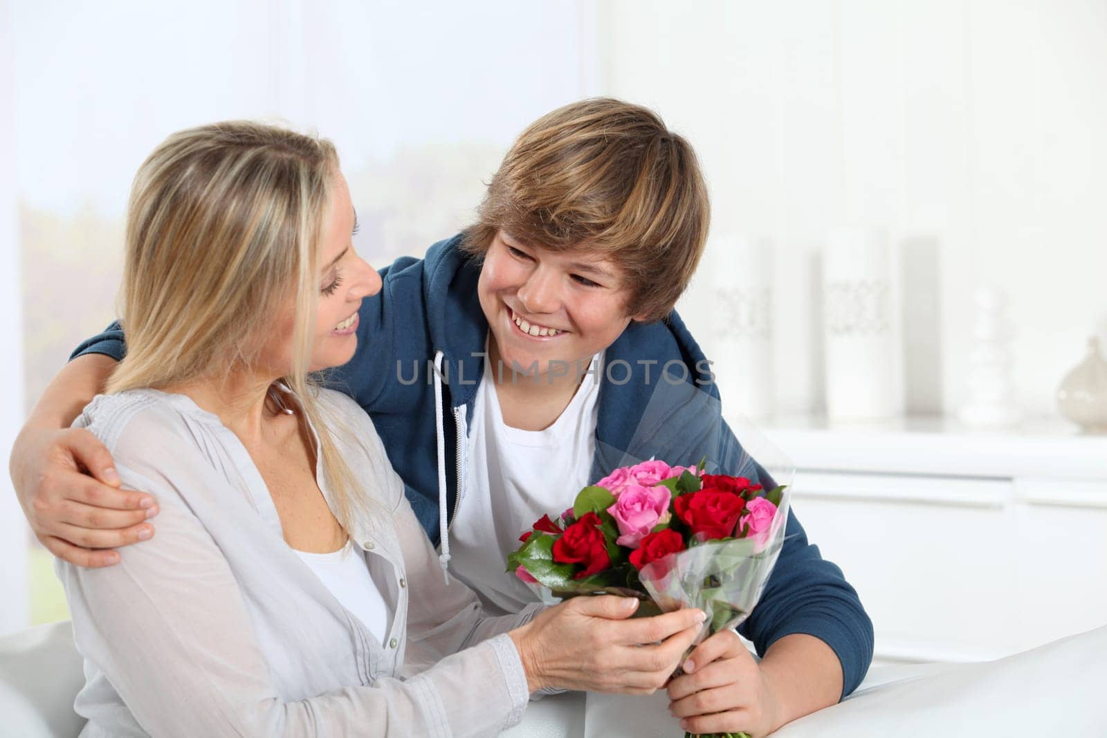 Son offering bunch flowers on mother's birthday