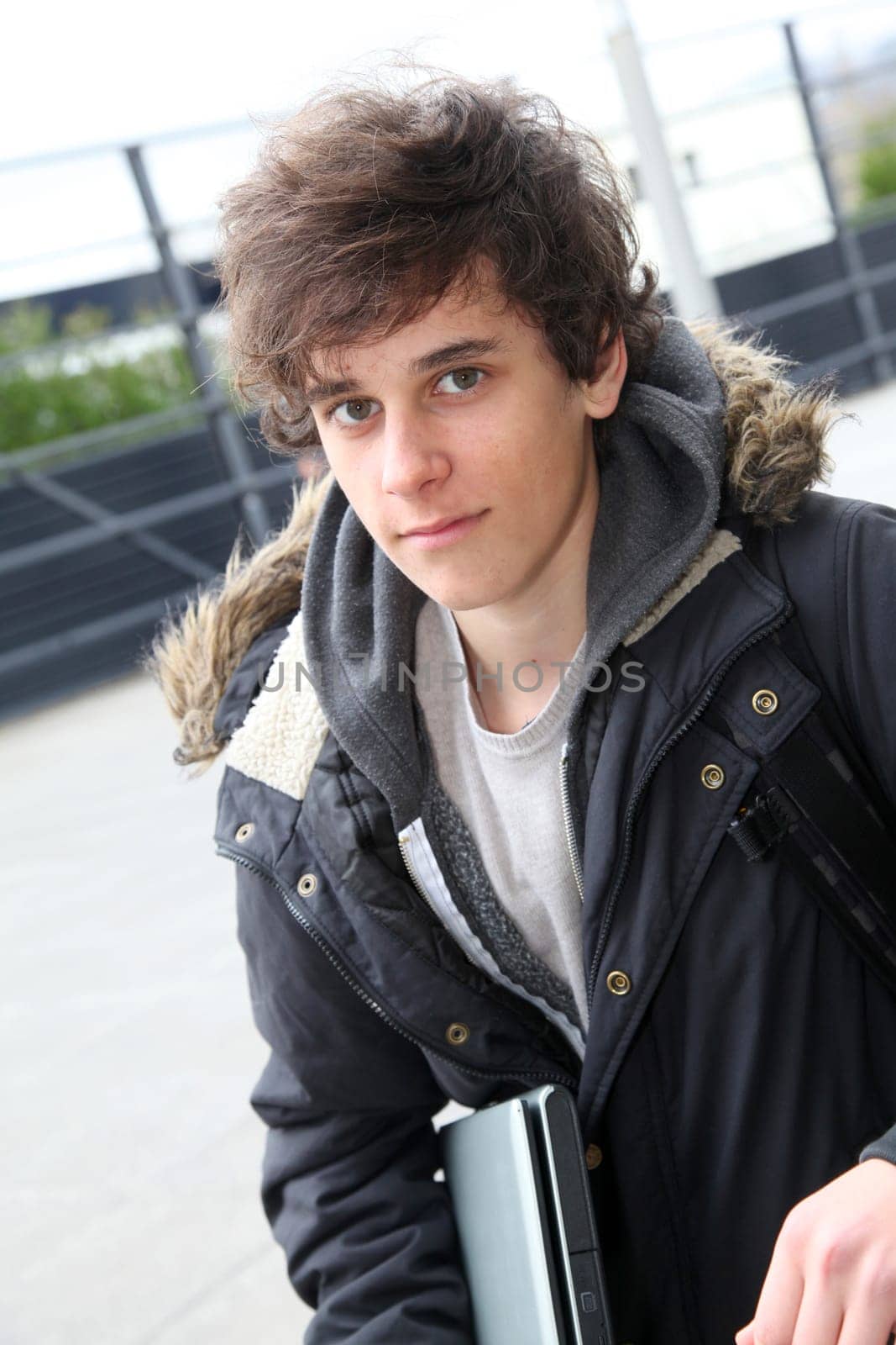 Portrait of teenage boy in front of school building