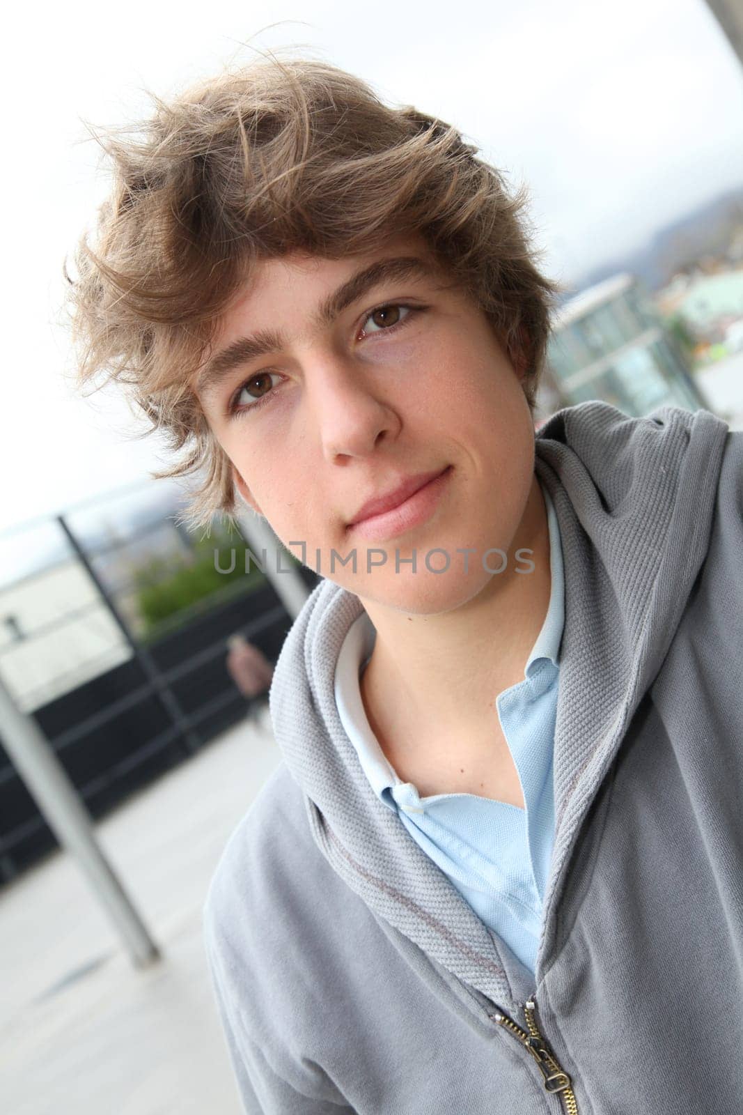Portrait of teenage boy in front of school building
