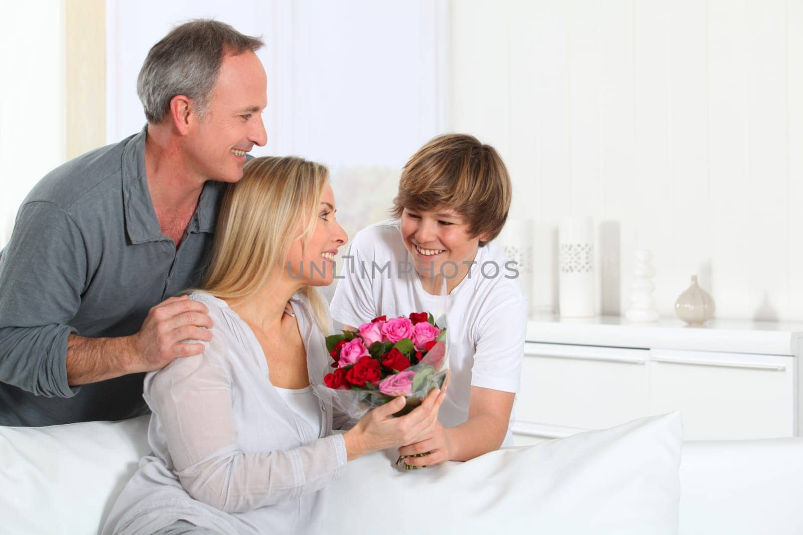 Son offering bunch flowers on mother's birthday