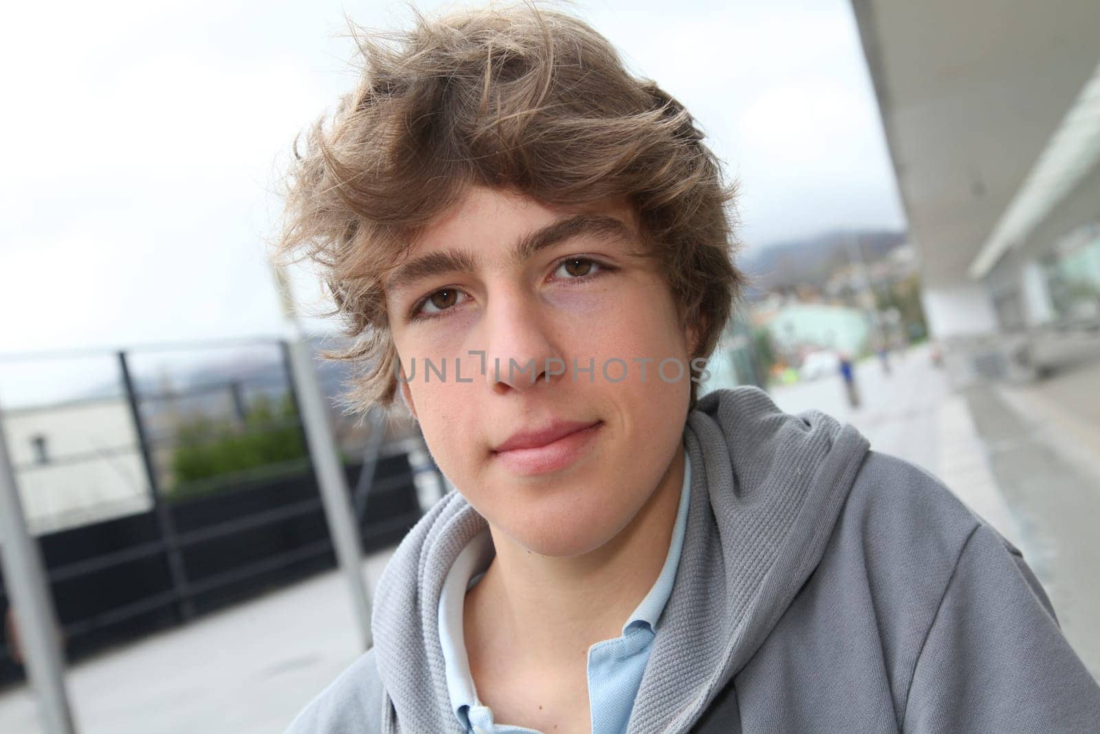 Portrait of teenage boy in front of school building