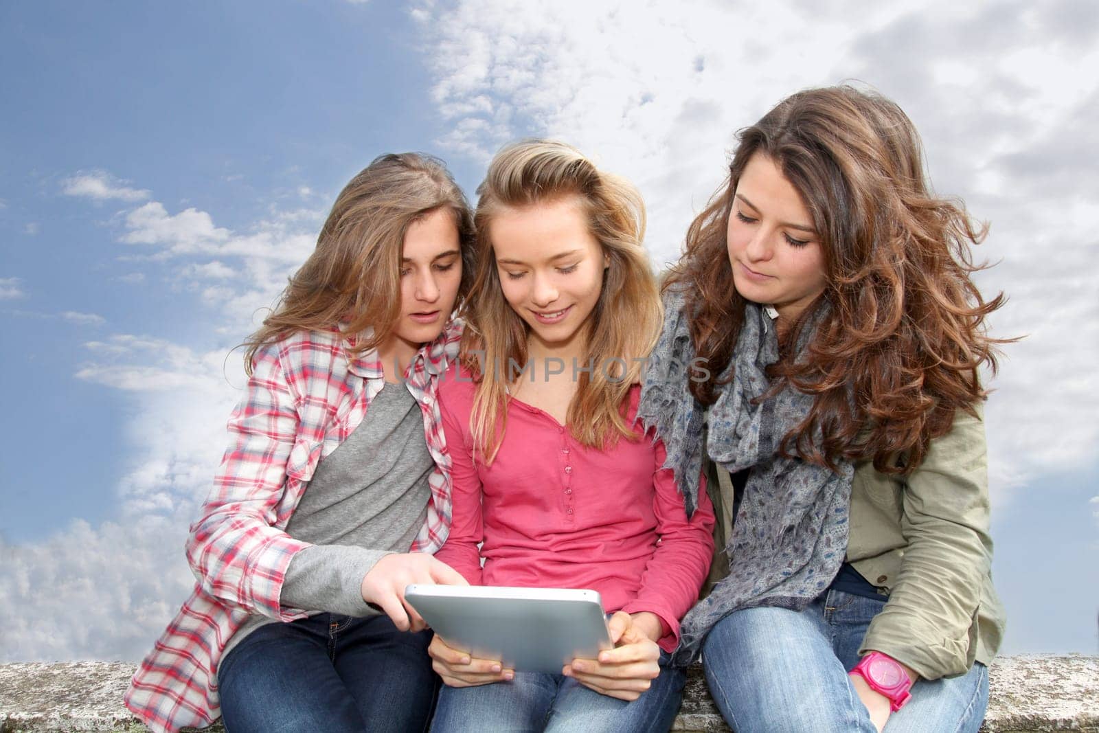 Group of teenage girls with laptop computer in school yard