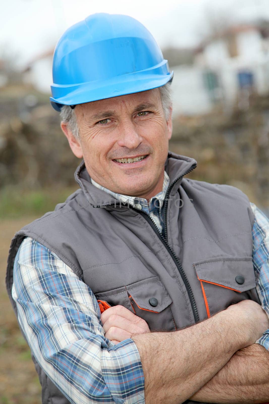 Portrait of smiling engineer with blue security helmet