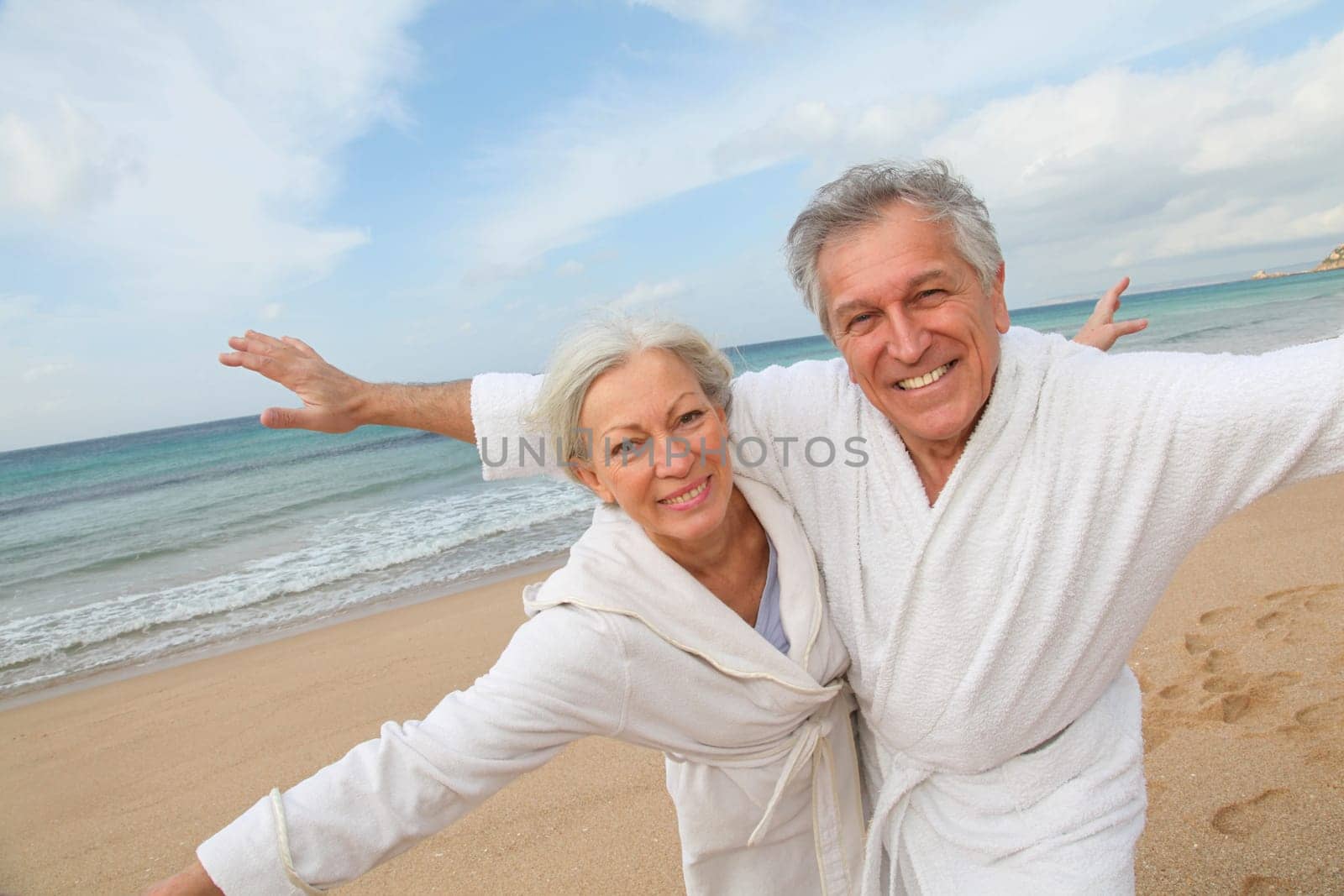 Senior couple in bathrobe at the beach