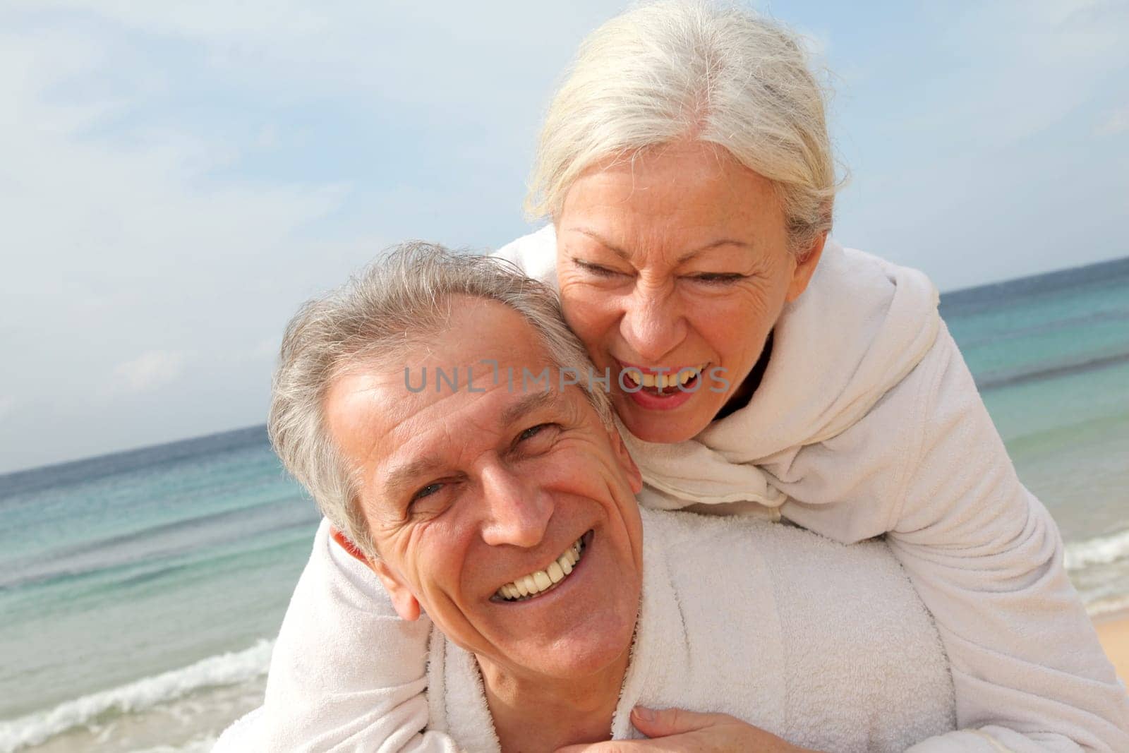 Senior couple in bathrobe at the beach