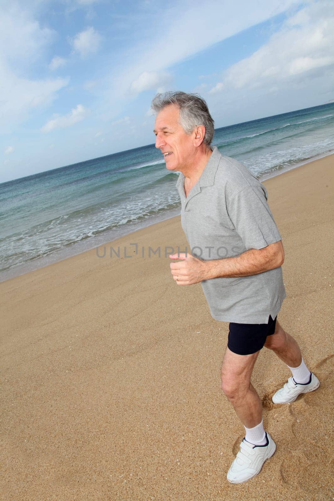 Senior man running on the beach