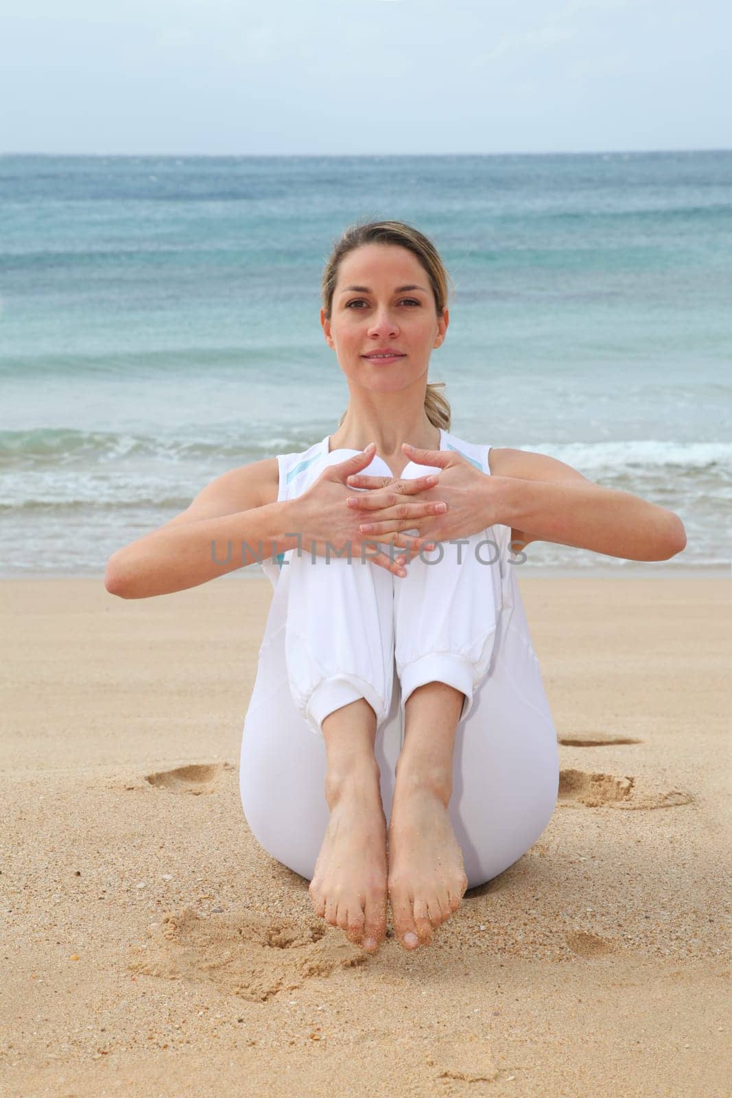 Woman doing stretching exercises at the beach