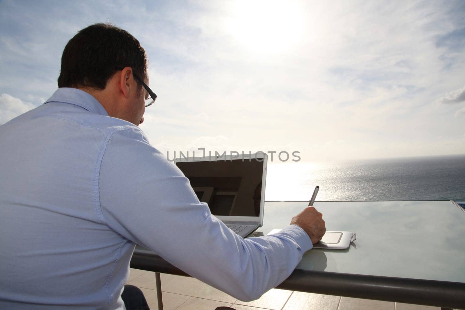 Man working in front of the sea during vacation time