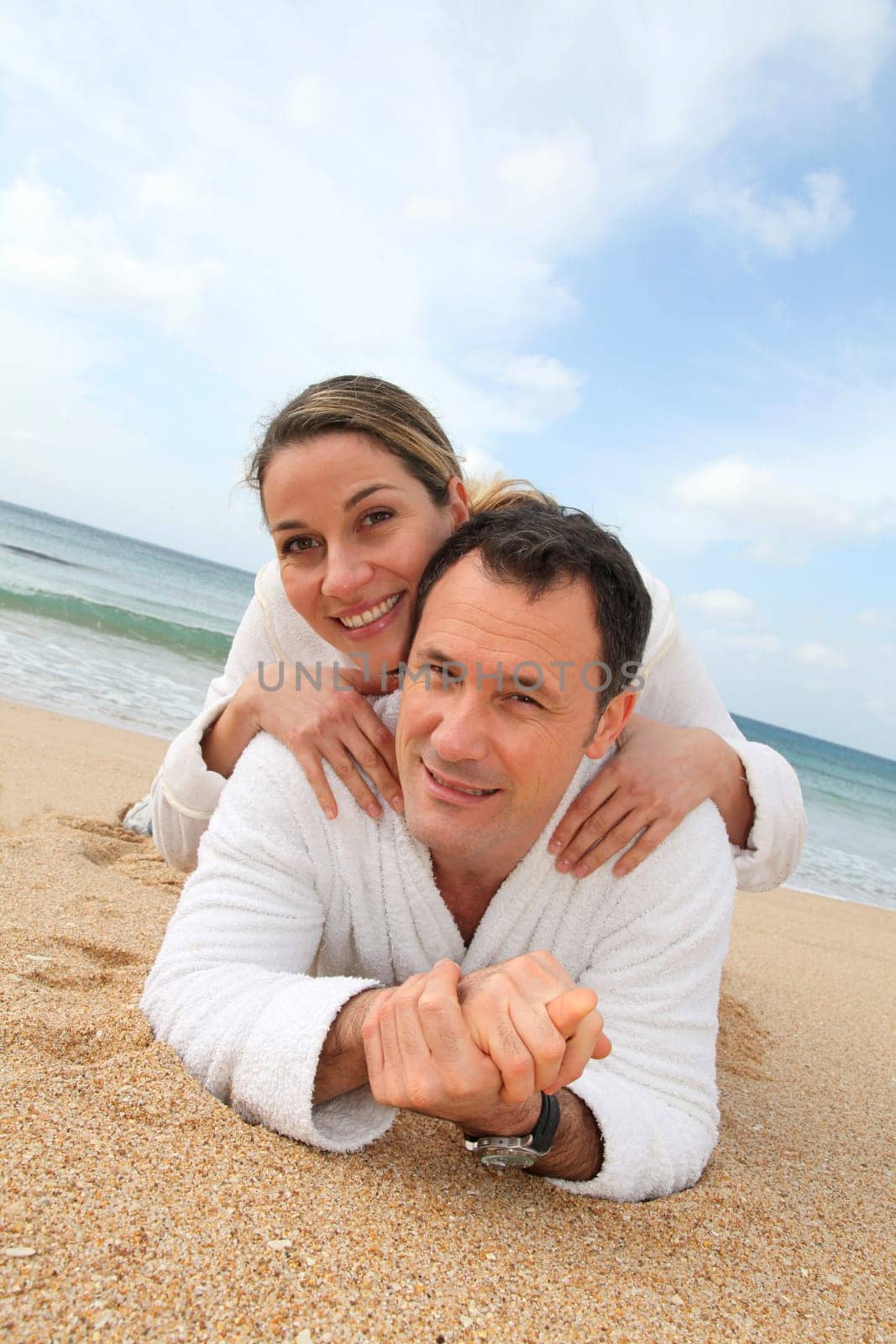 Couple relaxing in bathrobe at the beach